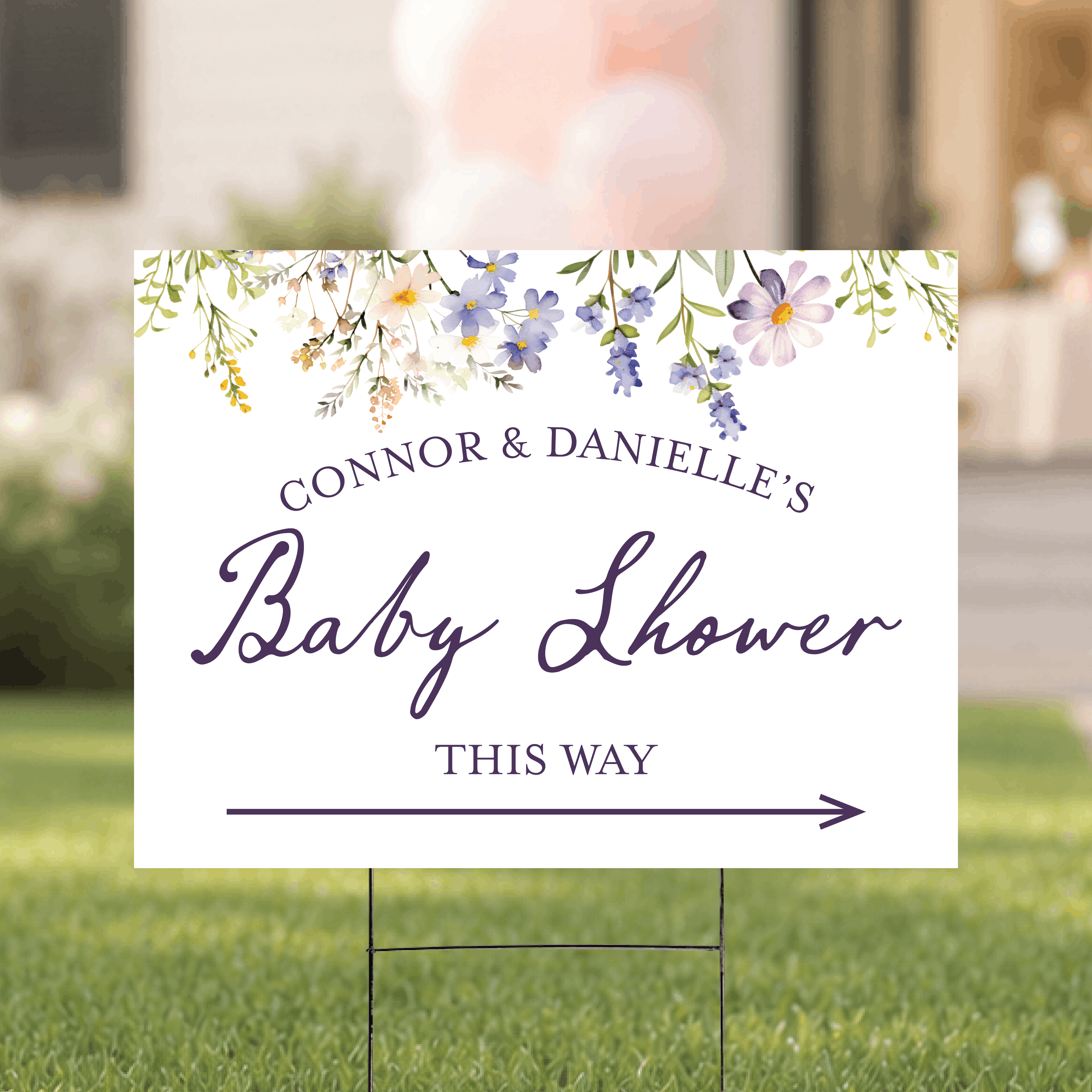 Personalized floral baby shower directional yard sign staked outdoors, featuring a vibrant botanical floral background with custom name and arrow.