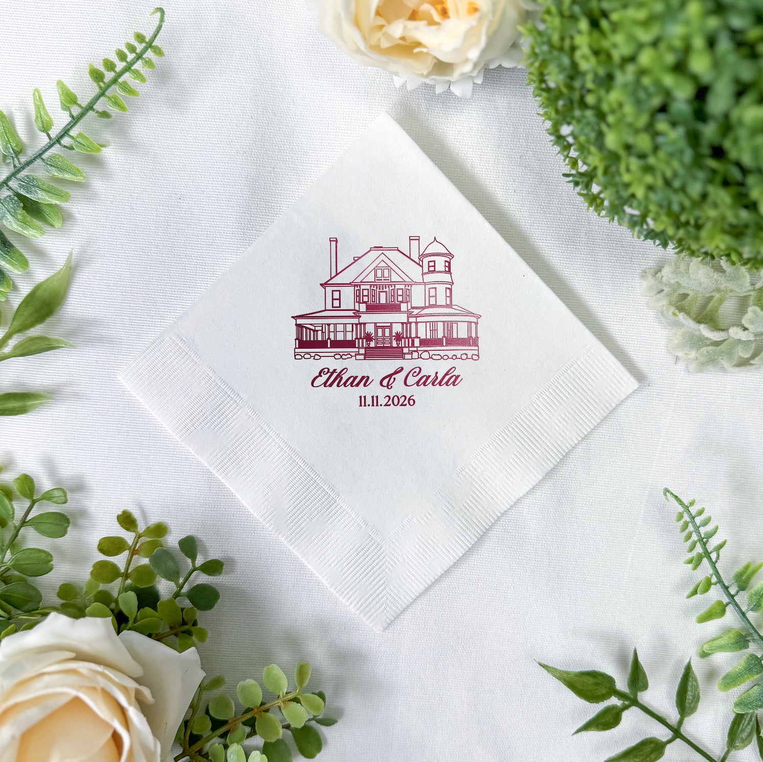 Personalized cocktail napkins with venue sketch design showing couple's names, venue illustration, and wedding date