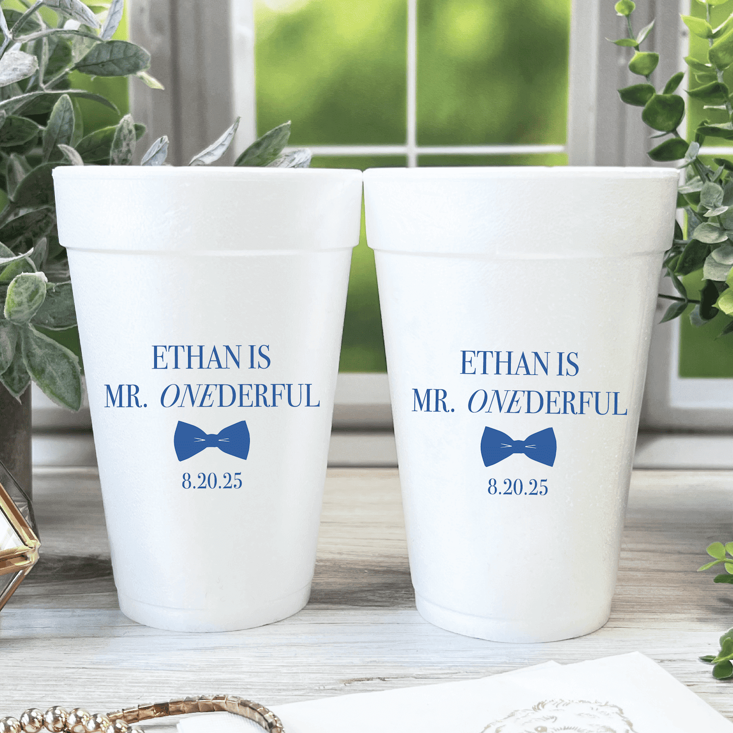 White foam cups with blue text reading "Ethan is Mr. Onderful" and "Ethan is Mr. Wonderful" with bow tie design and date 8.20.25