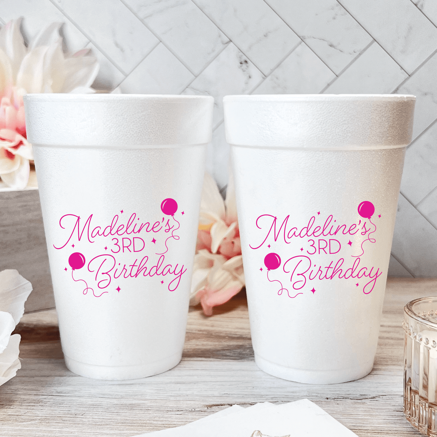 White foam cups with hot pink "Madeline's 3rd Birthday" text and balloon designs