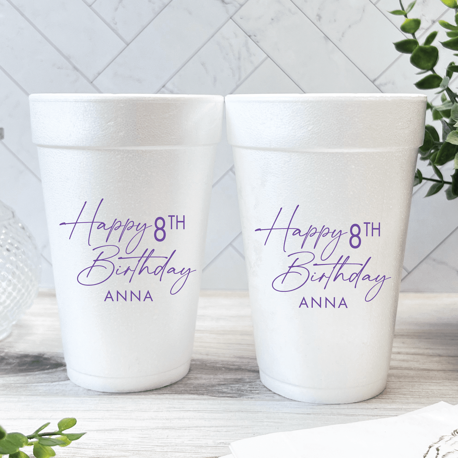 Two white foam cups with purple text reading "Happy 8TH Birthday ANNA" personalized for a birthday celebration