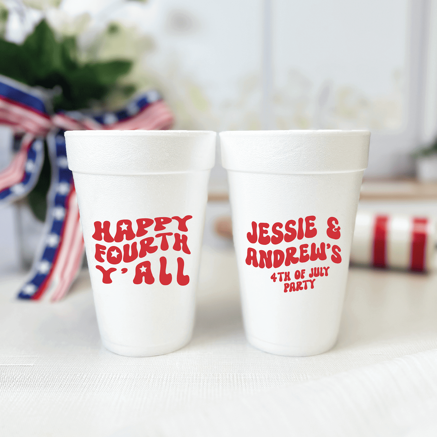 Two white foam cups with red text, one reading "Happy Fourth Y'all" and the other personalized "Jessie & Andrew's 4th of July Party"