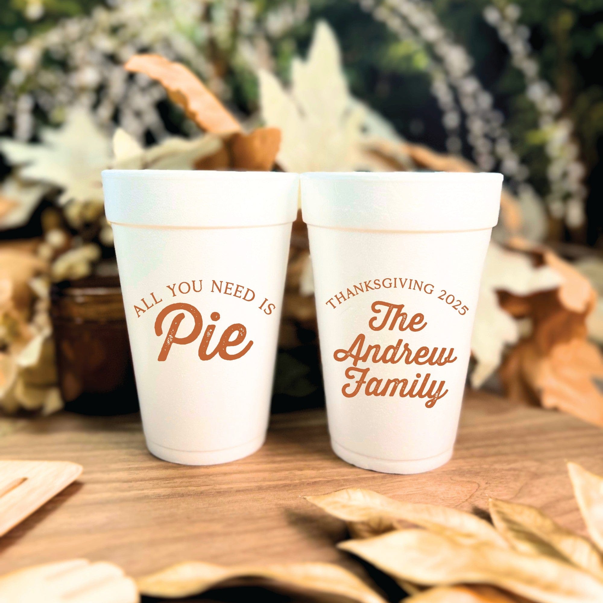 Two white foam cups featuring personalized autumn-themed designs, ideal for disposable drinkware at a Thanksgiving celebration.