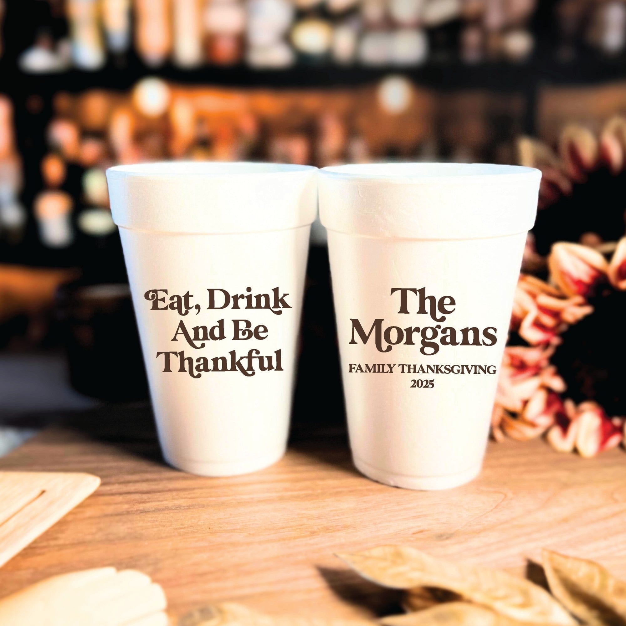Two white foam cups are personalized with dark brown text, suitable for a Thanksgiving celebration or festive gathering.