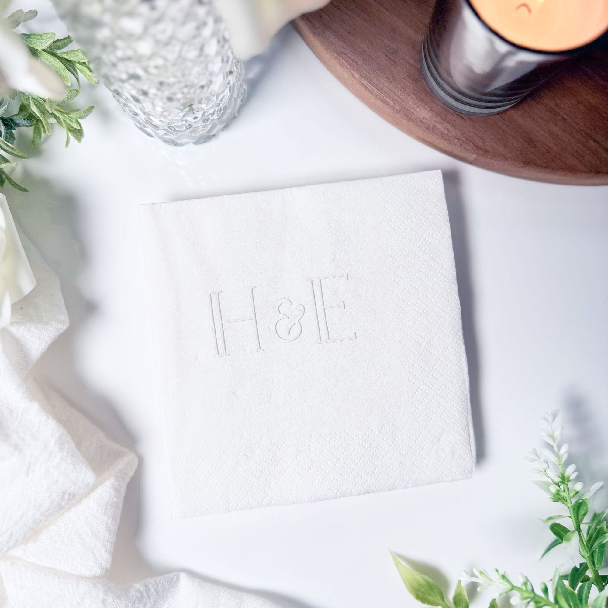 Personalized Embossed Cocktail Napkin Bold H&E Monogram Square Fold Styled on White Table – Rubi and Lib