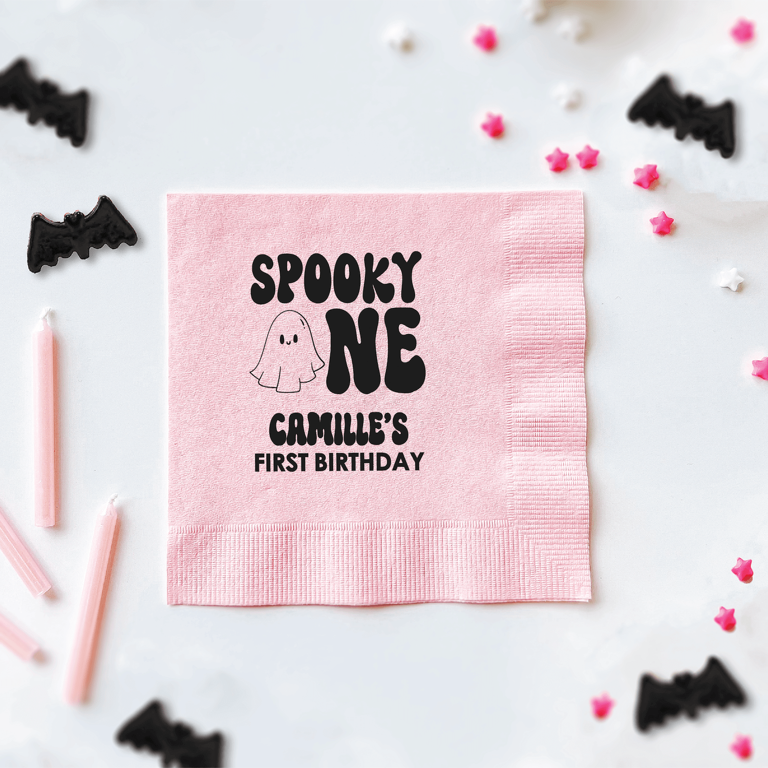 Pink napkin with "Spooky One" ghost design and "Camille's First Birthday" personalization in black text