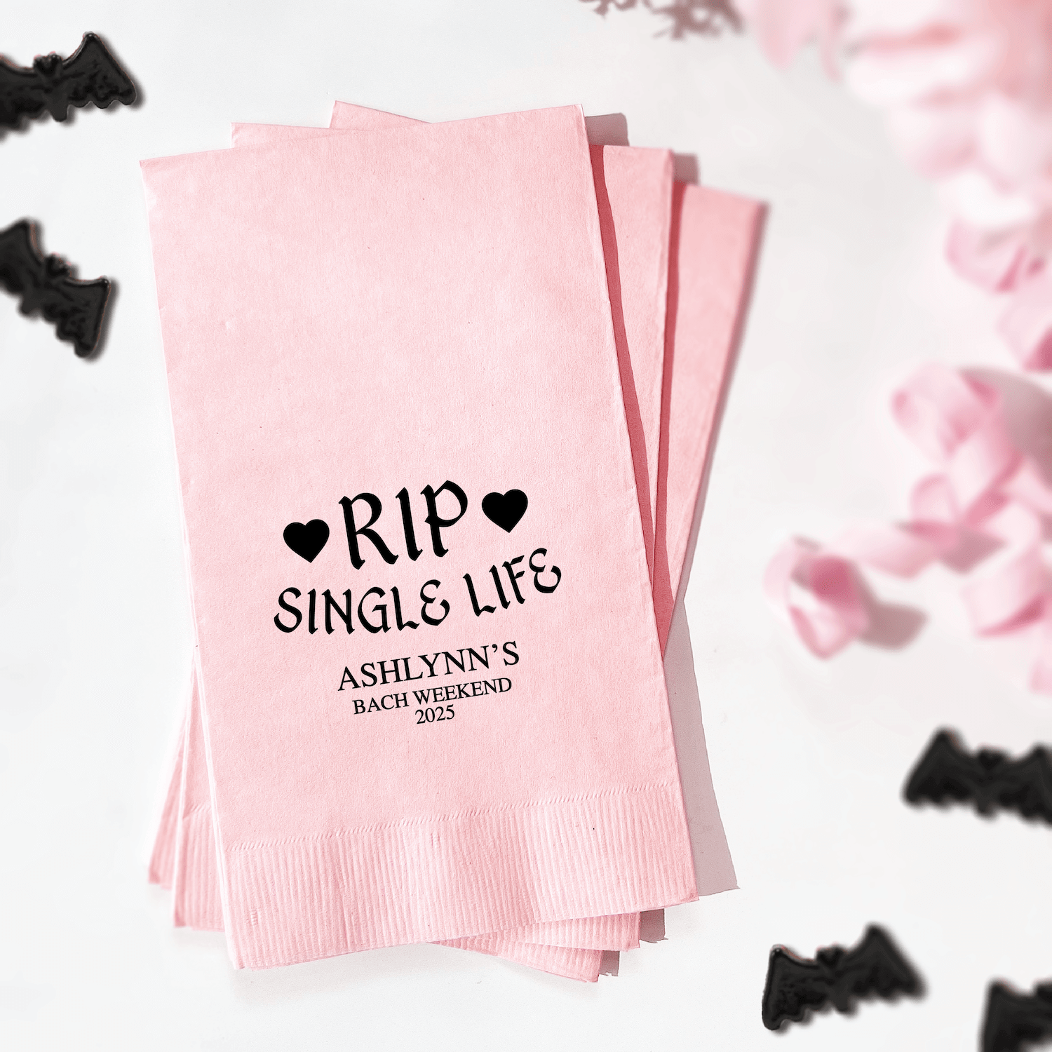 Pink napkins stacked with "RIP Single Life" text and heart designs, personalized with "Ashlynn's Bach Weekend" in black foil stamping.