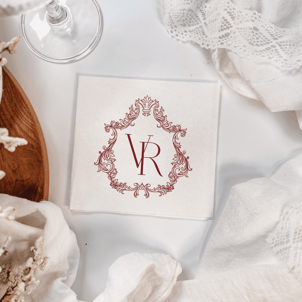 Cream napkin with burgundy ornate frame monogram and VR initials, foil stamped design