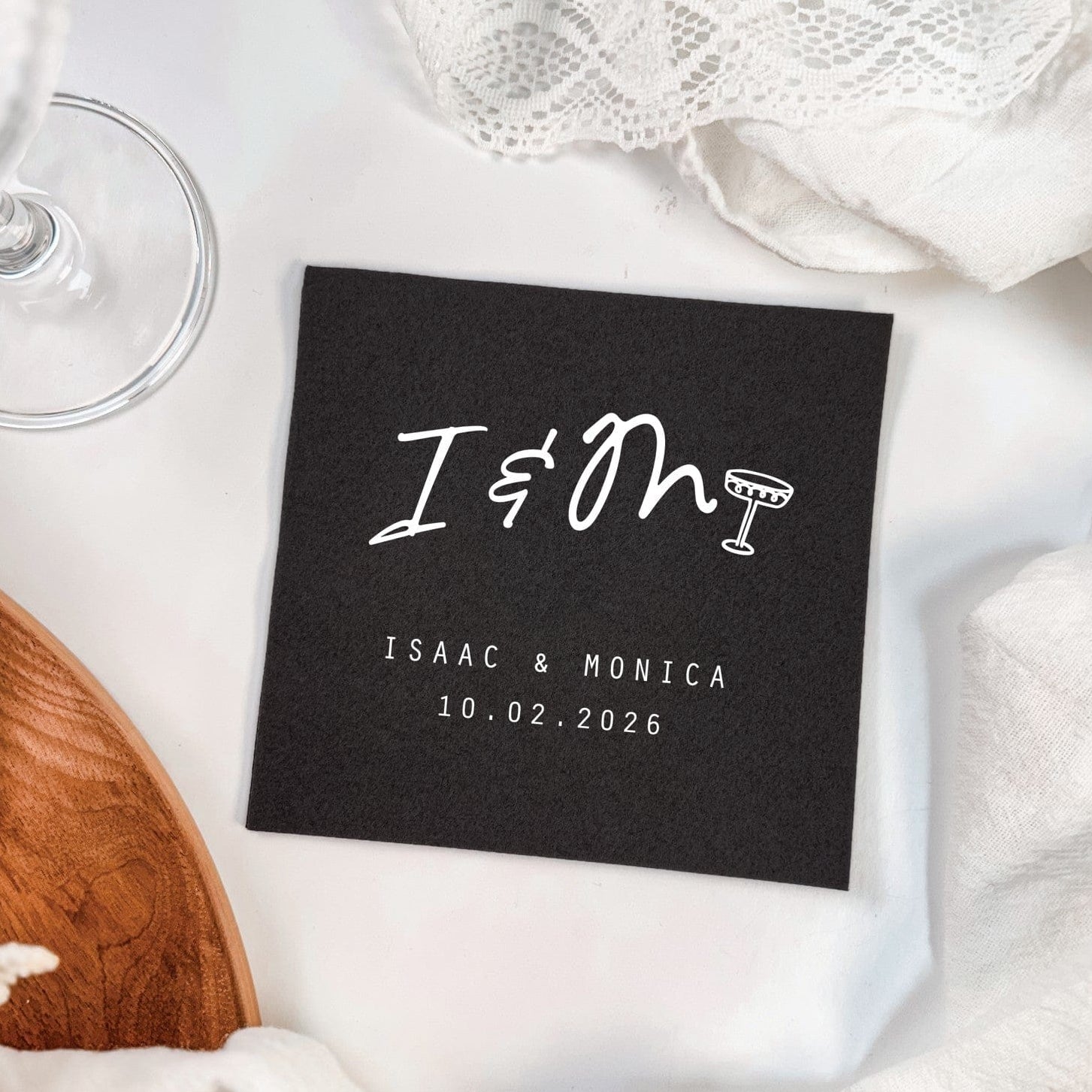 A black linen wedding napkin features a white custom graphic incorporating a champagne glass design, offering elegant personalized decor for a celebration.