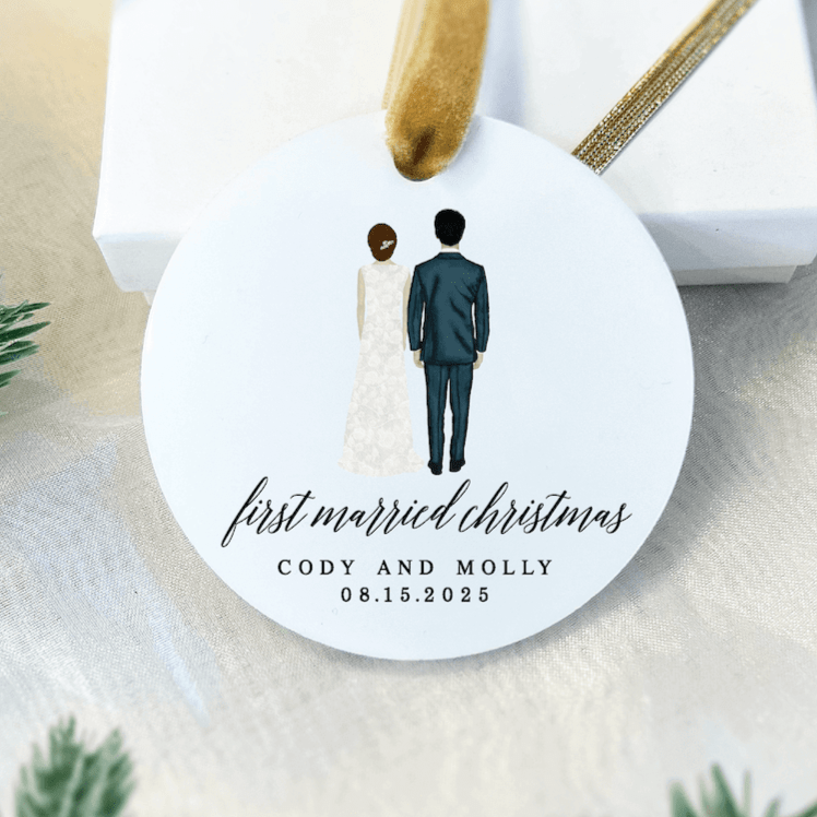 White acrylic ornament with illustrated couple in formal attire, "first married christmas" script text, and personalized names "Cody and Molly" with date 08.15.2025.