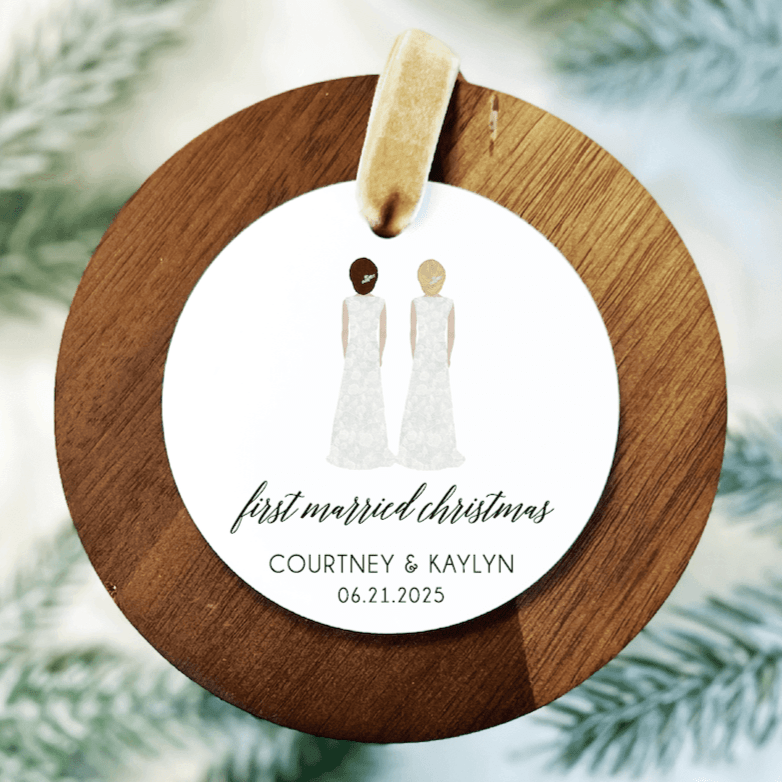 Wooden ring ornament with white acrylic circle featuring two bride figures, "first married christmas" text, and personalized names and date.