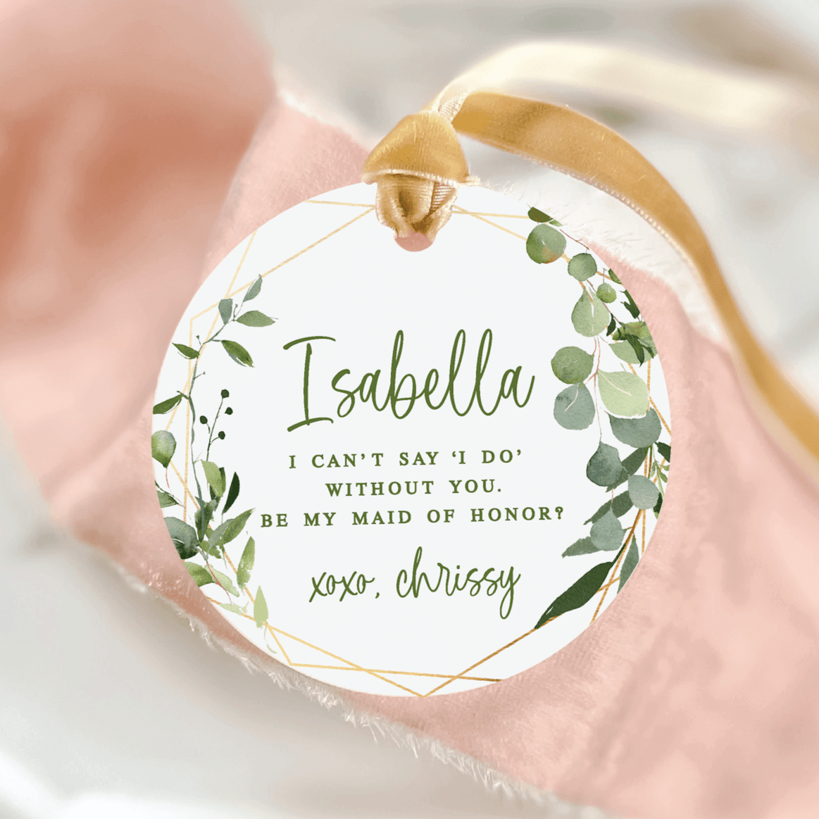White acrylic ornament with gold ribbon featuring personalized name Isabella and eucalyptus leaf design, maid of honor proposal message with signature detail.