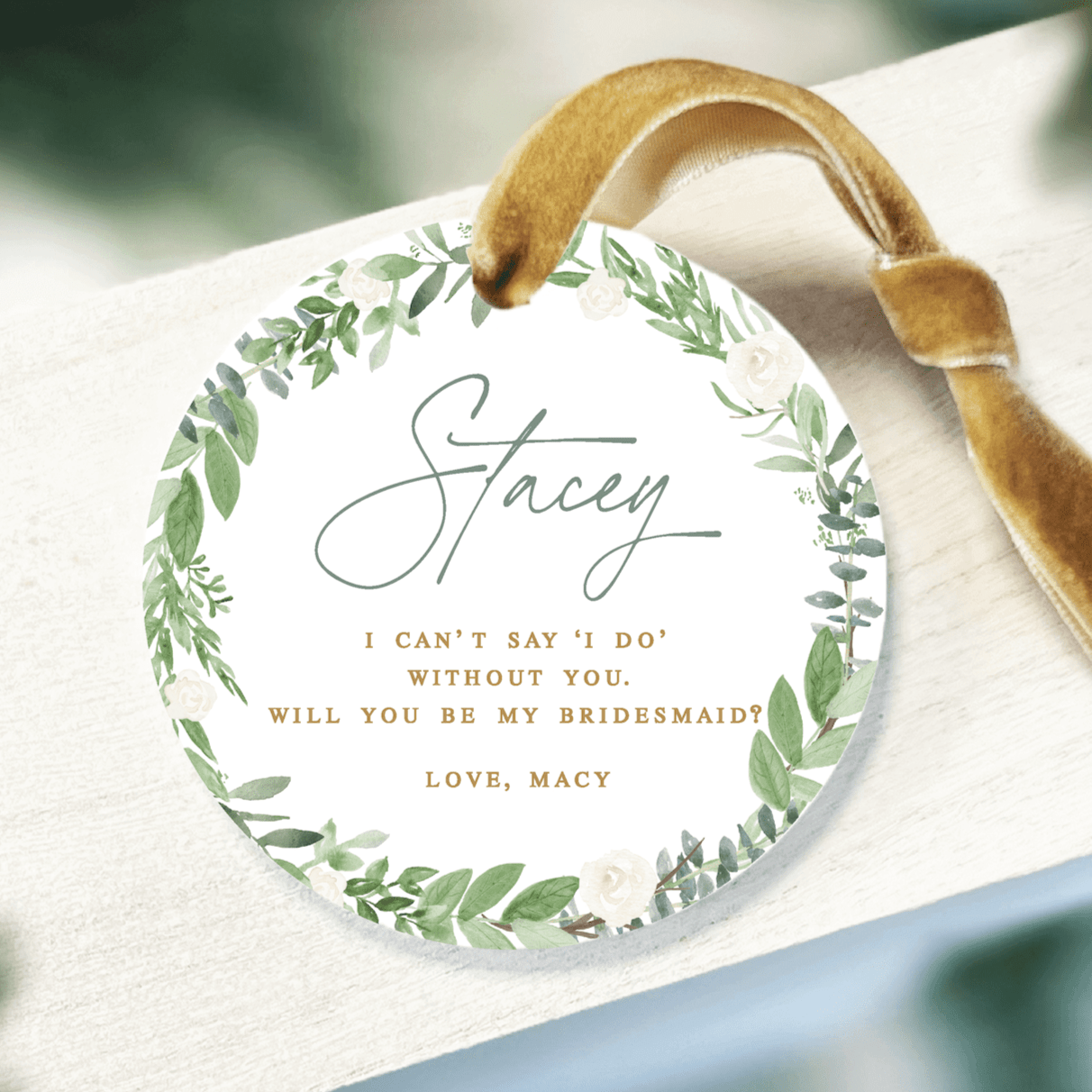 Round acrylic ornament with green leaf wreath border, personalized "Stacey" text, and bridesmaid proposal message with gold ribbon hanger.