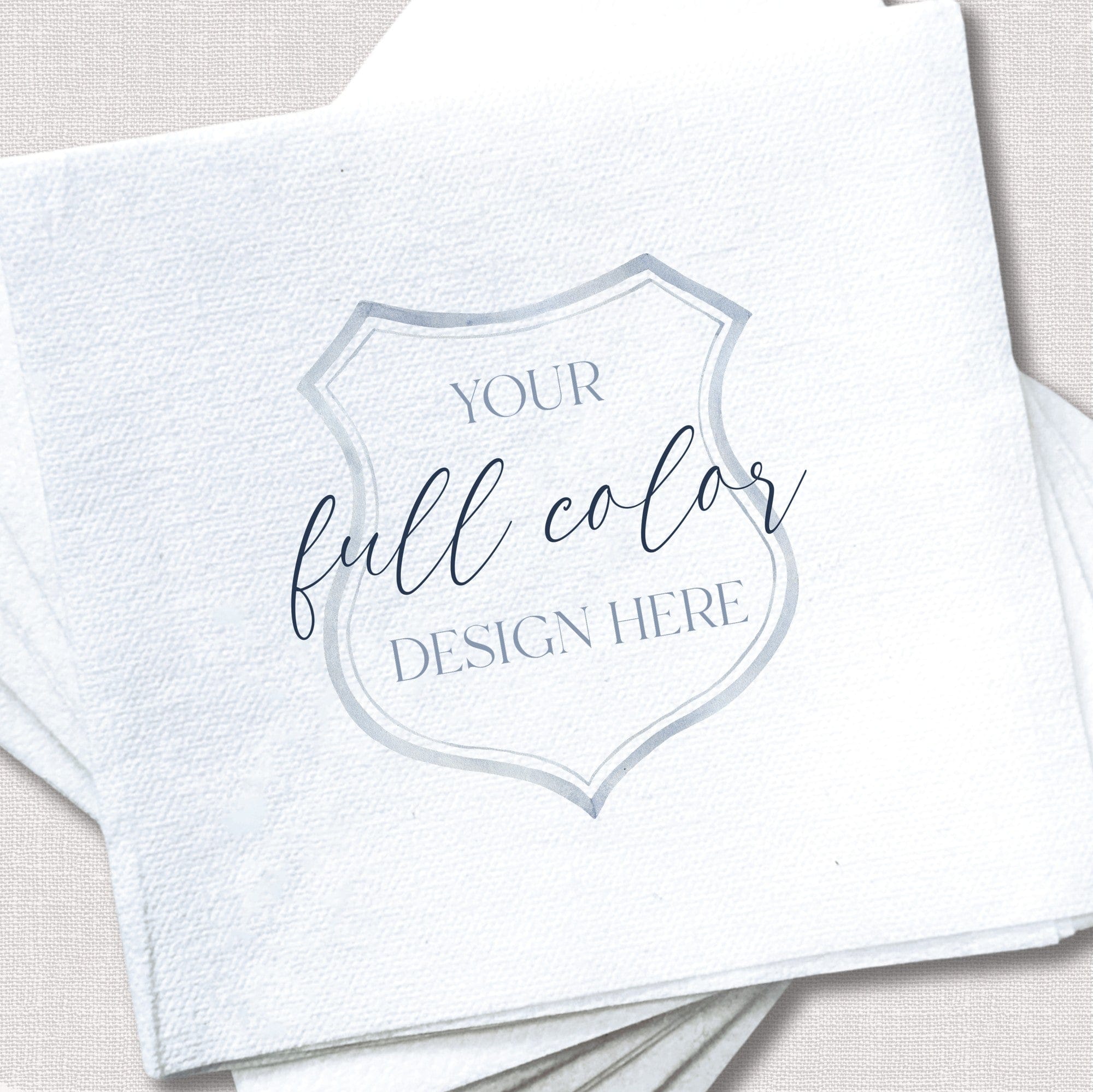 A stack of white textured paper cocktail napkins with a customizable full-color design area, perfect for a wedding or special event.