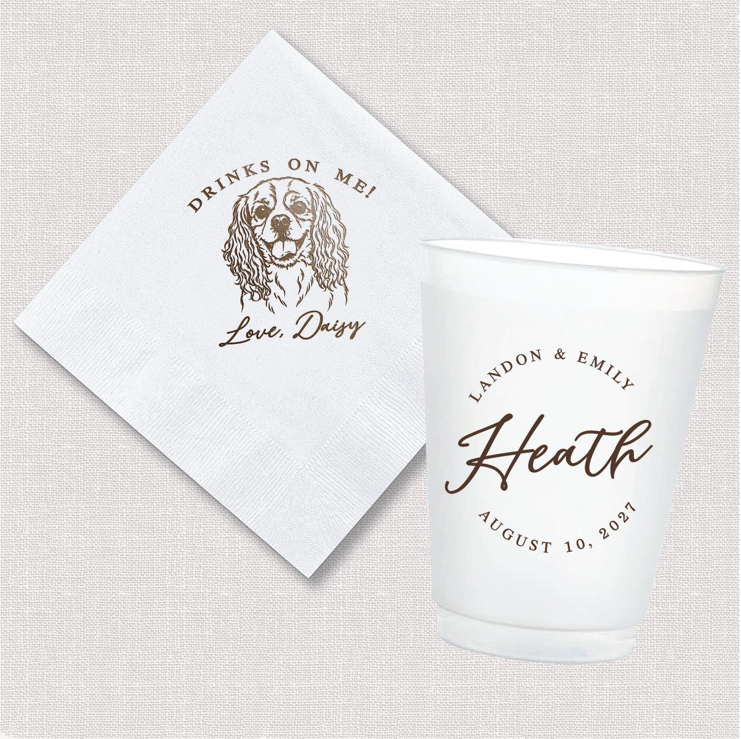 A white paper napkin with a custom pet illustration and a translucent white plastic shatterproof cup with custom text are displayed as a personalized wedding drinkware set.