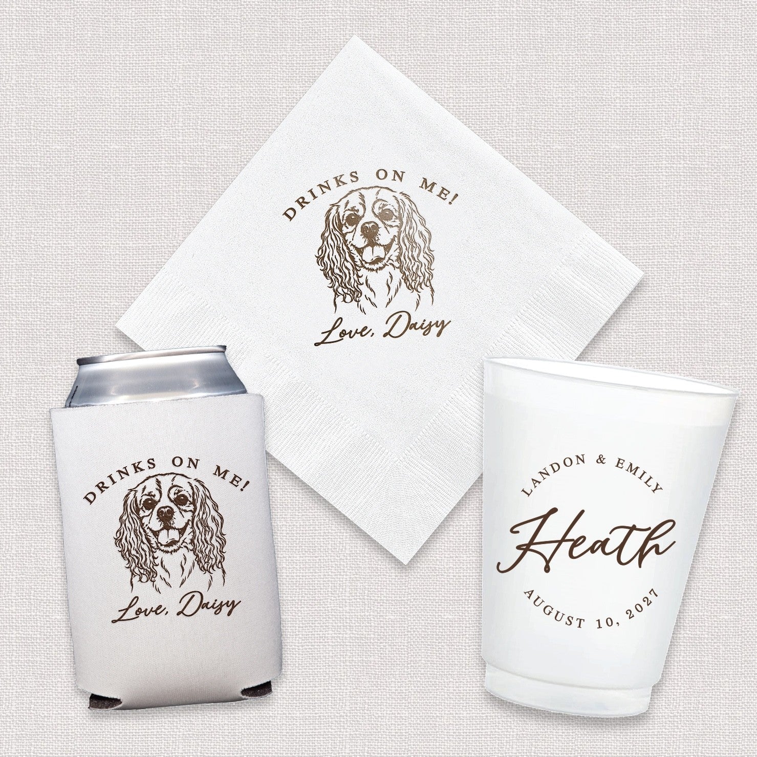 A personalized wedding or event decor set featuring a white disposable beverage napkin, a white neoprene can koozie, and a white plastic cup, all with matching custom brown printed designs including a dog illustration and celebratory text.