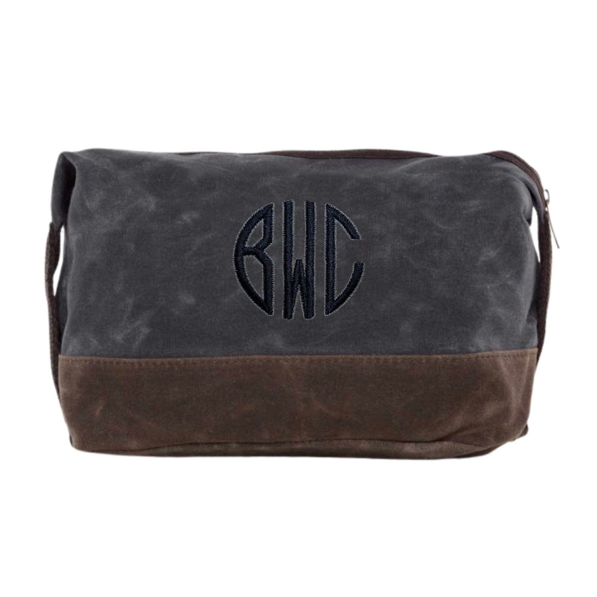 A personalized two-tone waxed canvas toiletry bag in dark grey and brown, featuring an embroidered circular monogram design and a top zipper closure, perfect for travel essentials or as a wedding party gift.