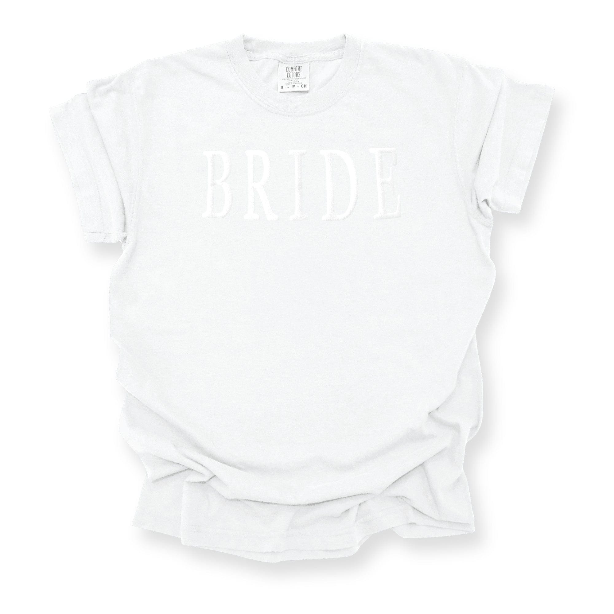 A white short-sleeve t-shirt features subtle white raised lettering, perfect for bridal events.