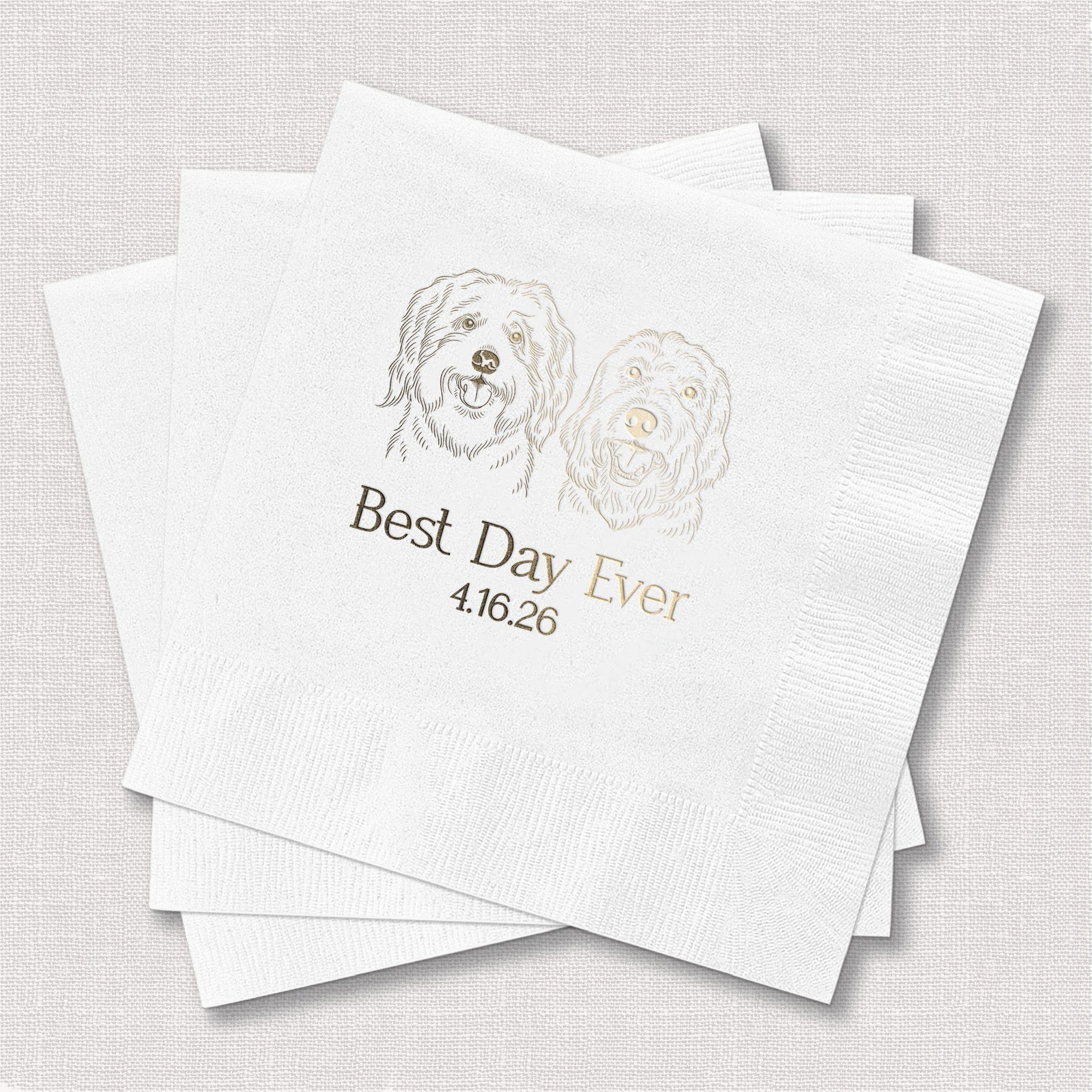 A stack of white textured paper napkins featuring a metallic gold foil custom illustration of two dogs, suitable for a personalized wedding or special event.