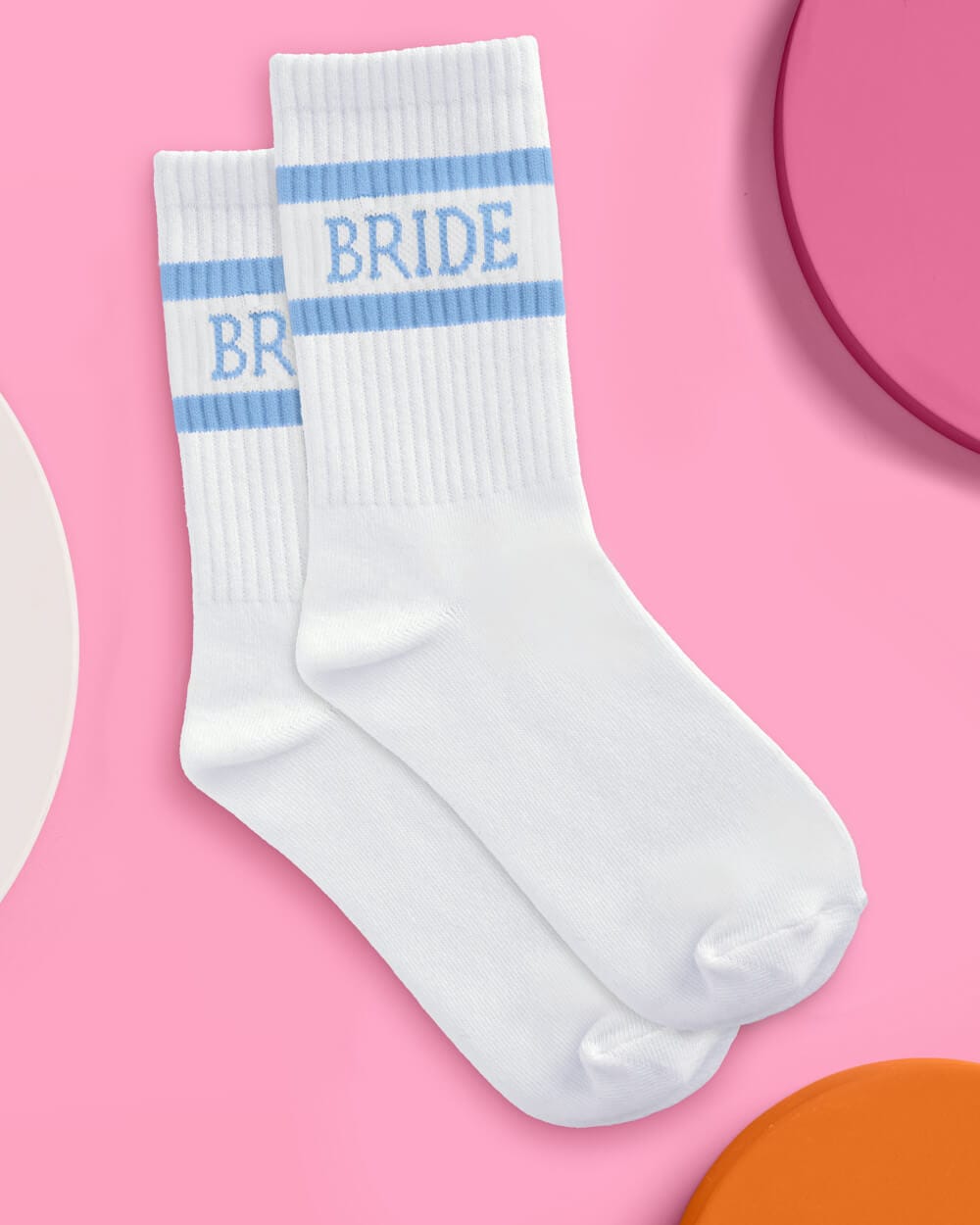 White crew socks with blue striped cuff and "BRIDE" text on pink background