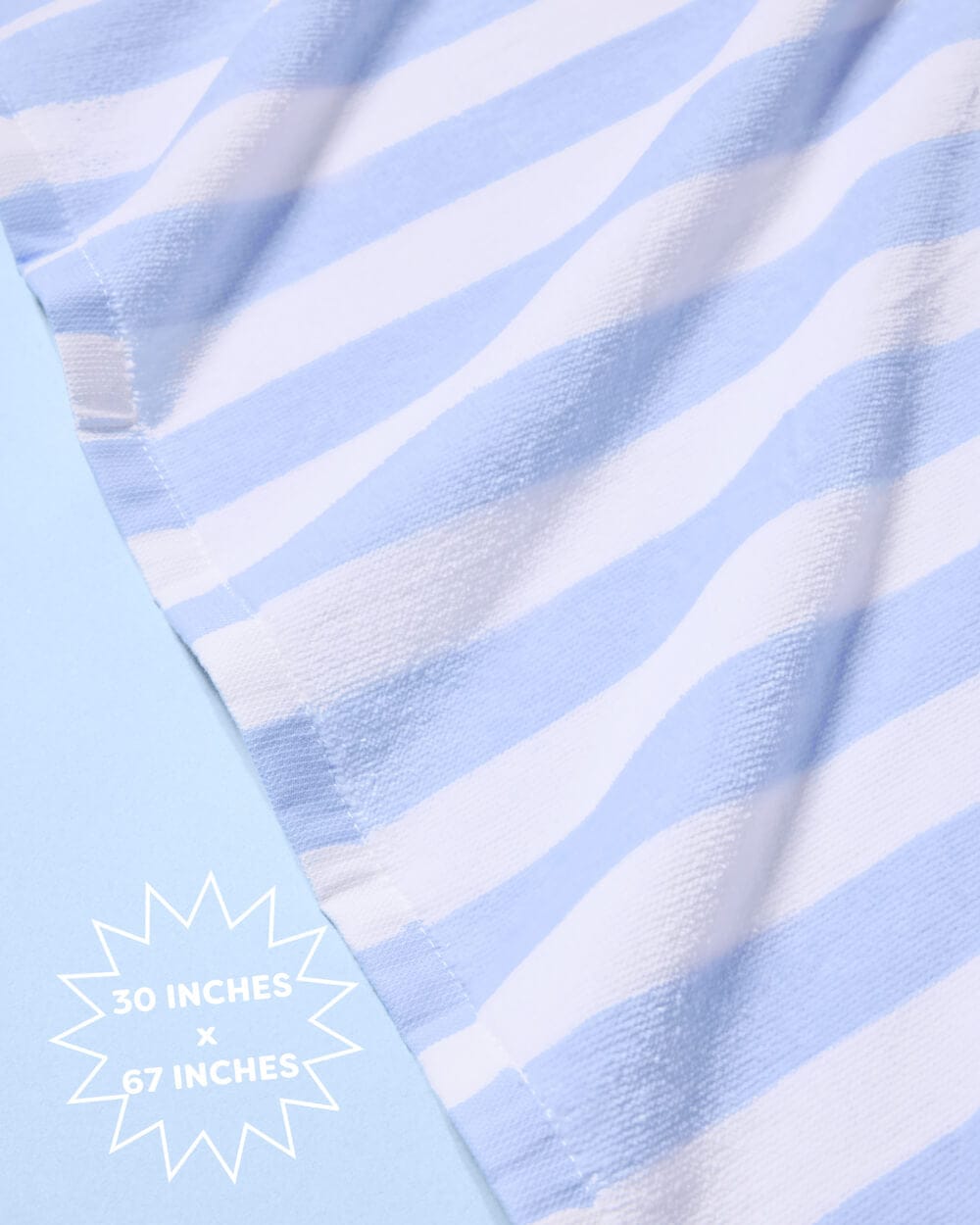 Light blue and white striped cotton beach towel with dimensions of 50 by 67 inches displayed against a blue background.