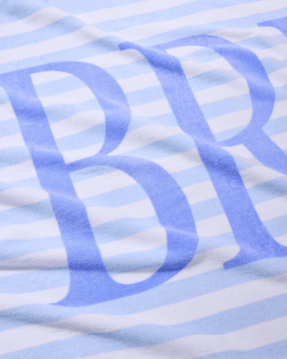 Blue and white striped cotton beach towel with curved script lettering design