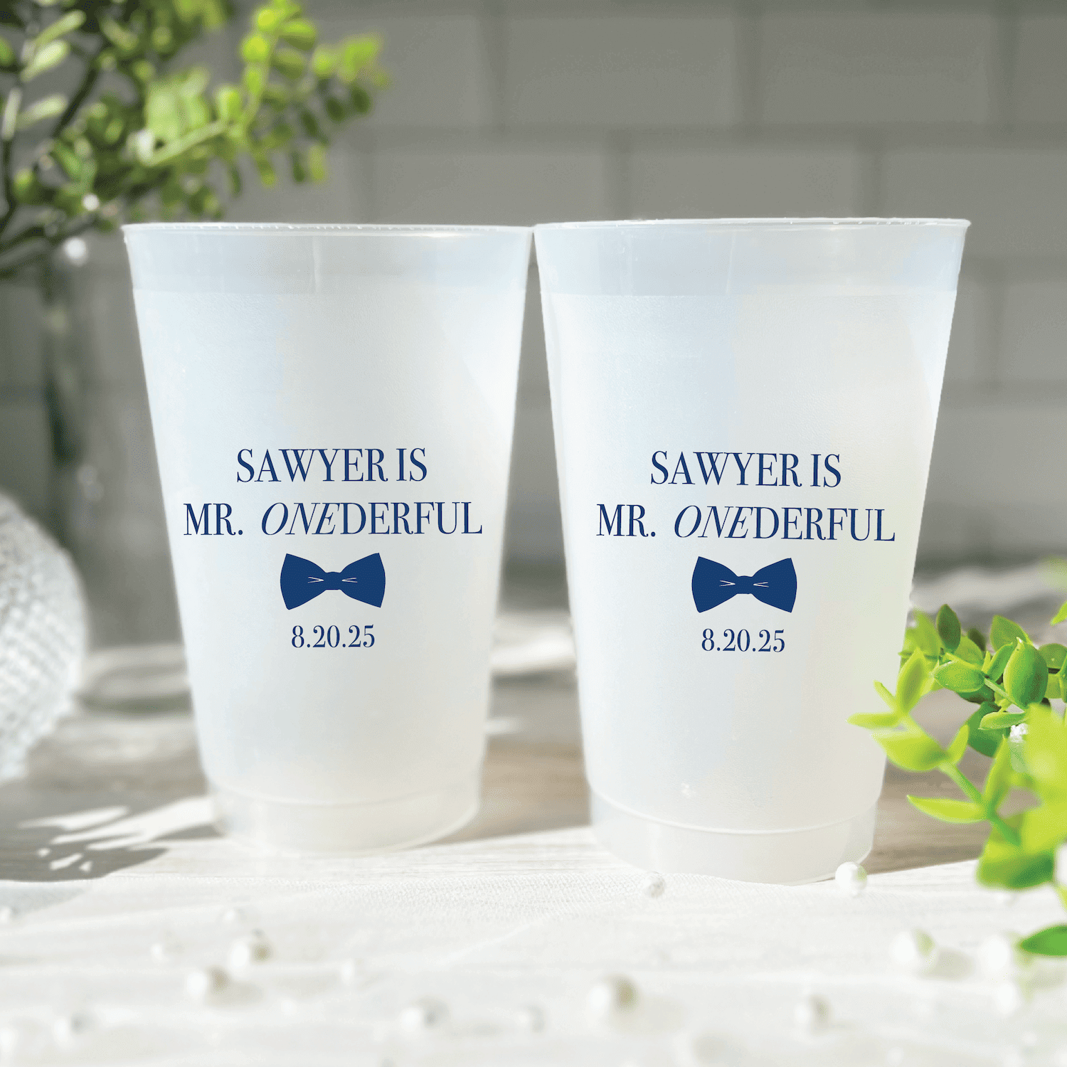 Two frosted plastic cups with "Sawyer is Mr. ONDERFUL" text and blue bow tie design, date 8.20.25 printed below