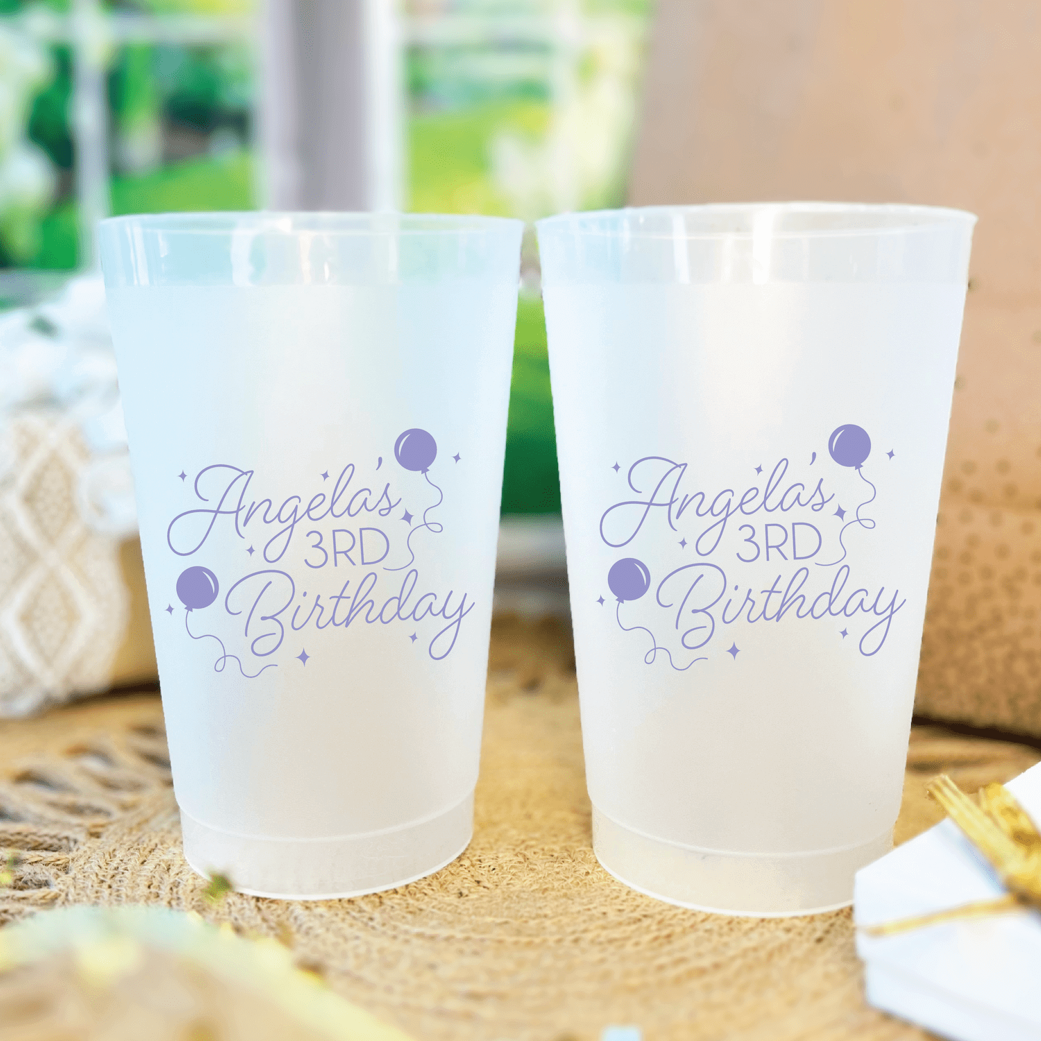 Frosted plastic cups personalized with "Angelina's 3rd Birthday" in purple script with balloon designs