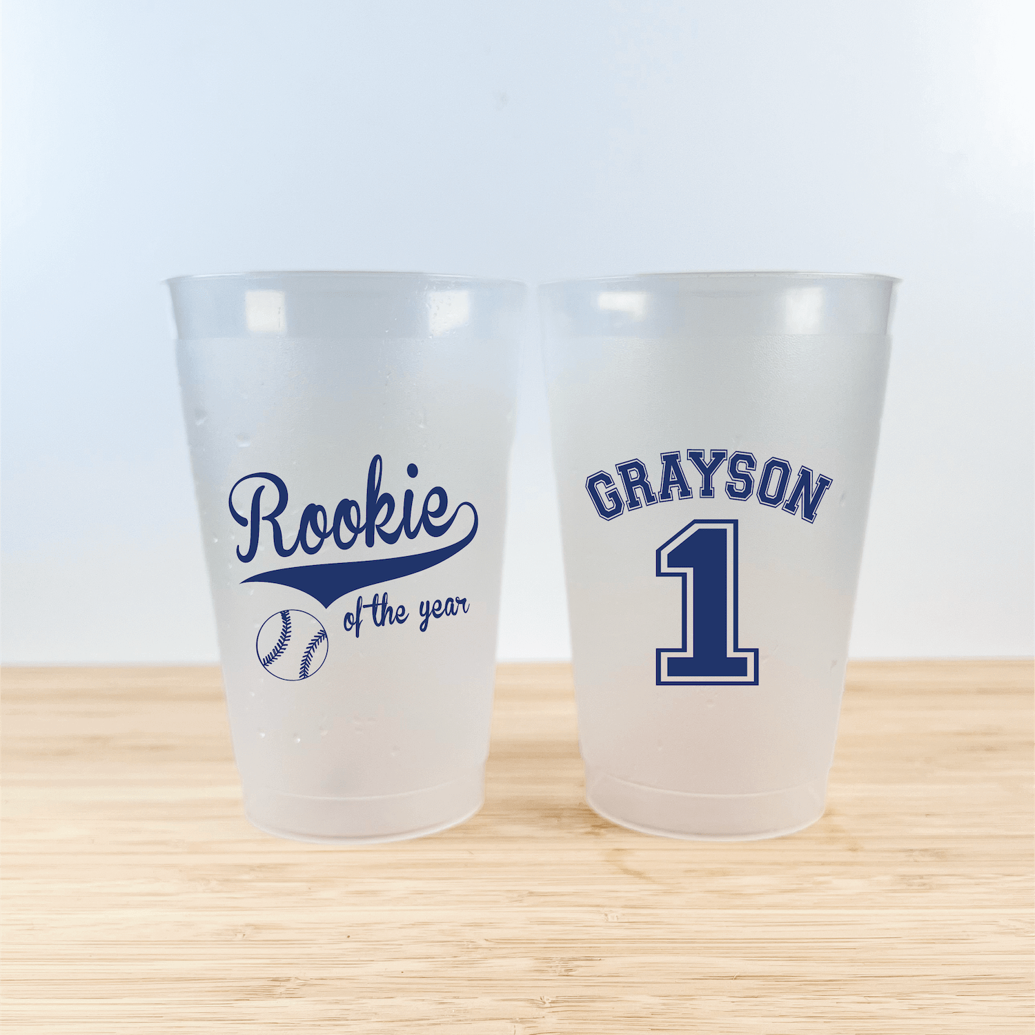 Pair of frosted shatterproof cups with "Rookie of the Year" and baseball design on one side, personalized name "GRAYSON" and number "1" on the other side in navy blue print.