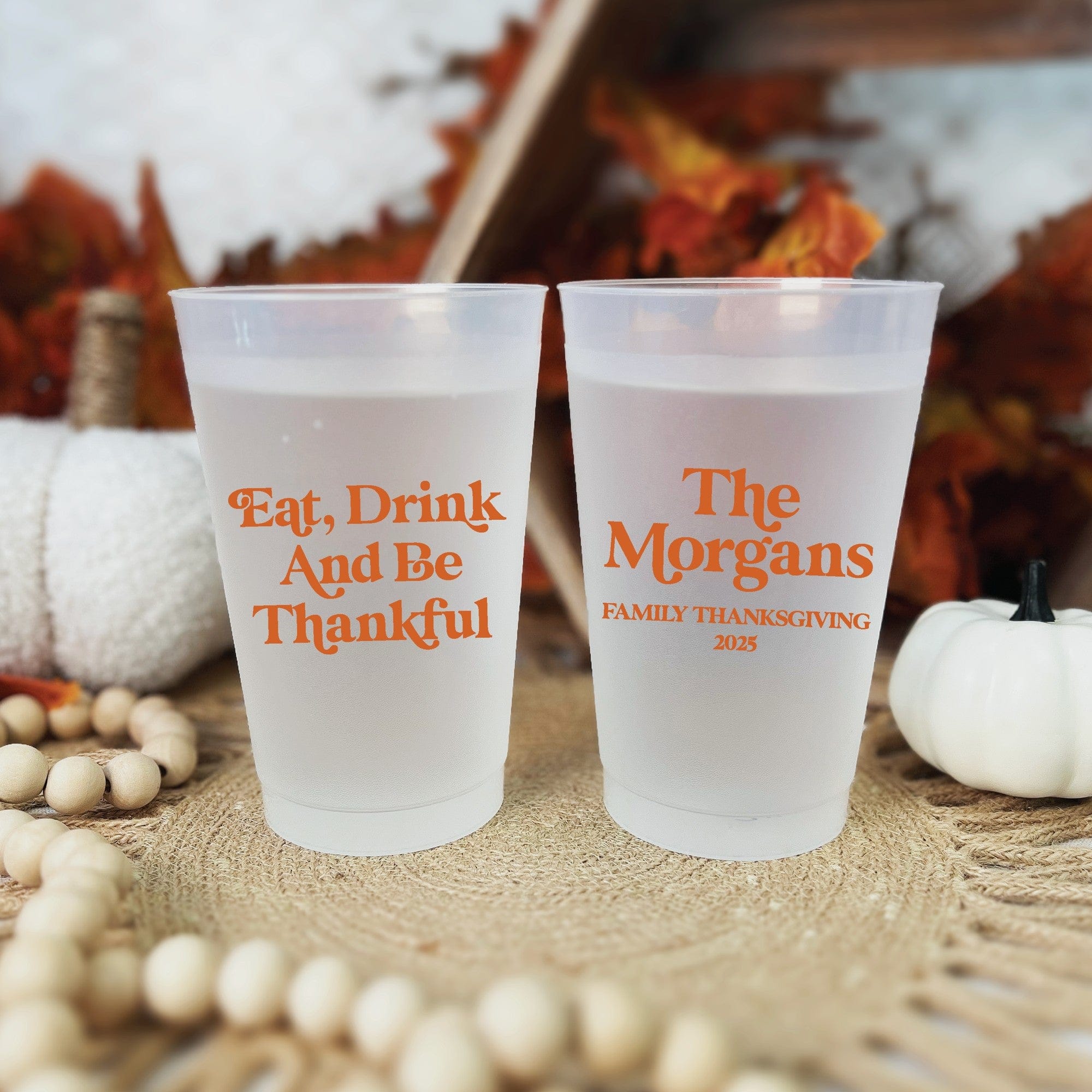 Two frosted plastic cups featuring custom orange text, ideal for a fall event or Thanksgiving celebration.