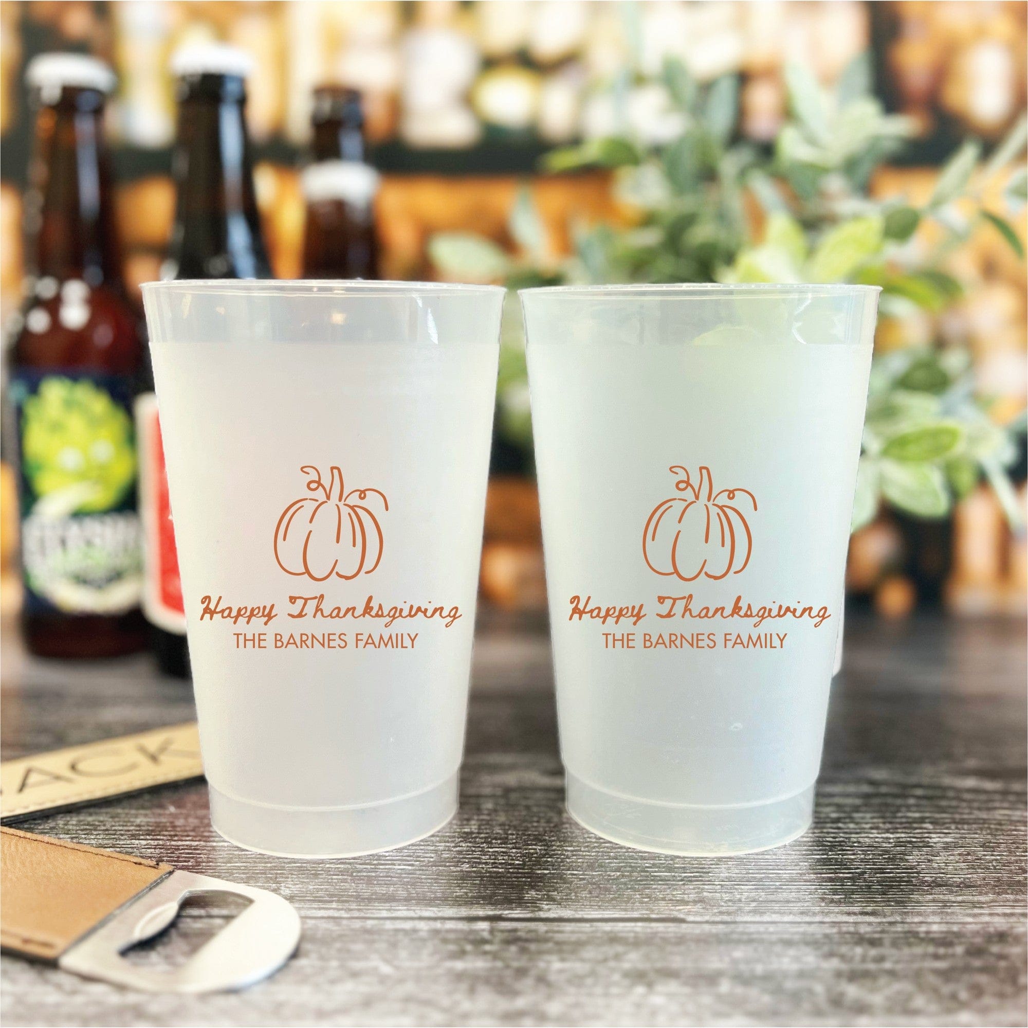 Two translucent frosted plastic party cups are customized with a warm orange pumpkin outline design, ideal for a festive fall or Thanksgiving celebration.