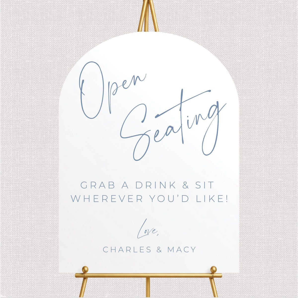 Elegant arched open seating wedding sign with dusty blue script lettering, personalized couple's names, and grab a drink and sit anywhere message.