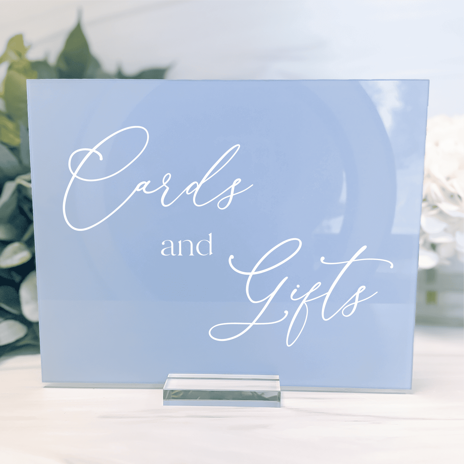 Light blue acrylic wedding sign with white script text reading "Cards and Gifts" on white stand