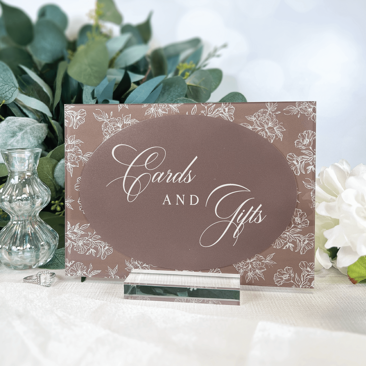Taupe acrylic sign with "Cards and Gifts" in elegant script, featuring delicate toile floral border design, displayed with greenery and white flowers.