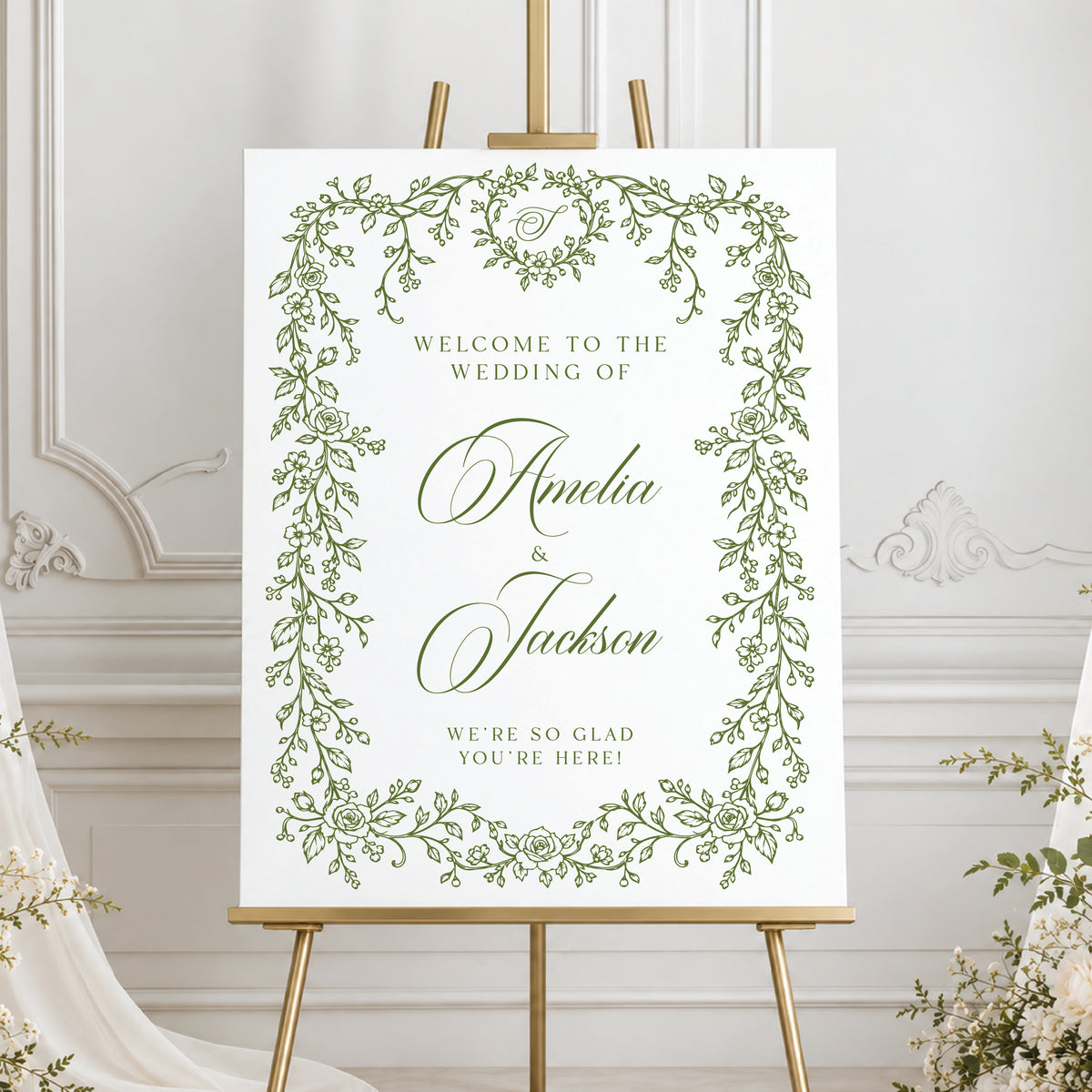 Custom floral wedding welcome sign featuring green botanical vines, romantic script lettering, and elegant ivory wedding drapery.