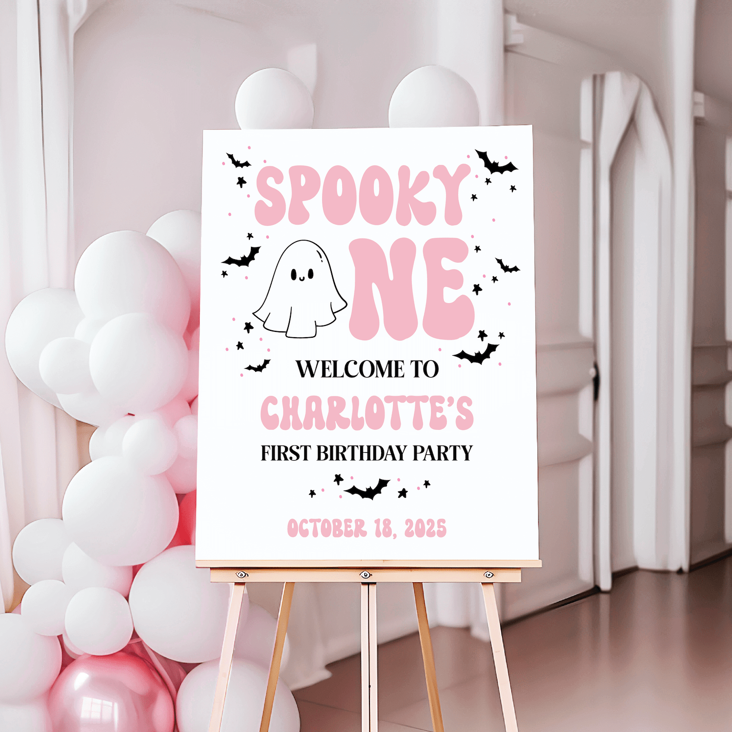 White welcome sign with pink "Spooky One" text, ghost and bat illustrations, personalized with name and date for first birthday party
