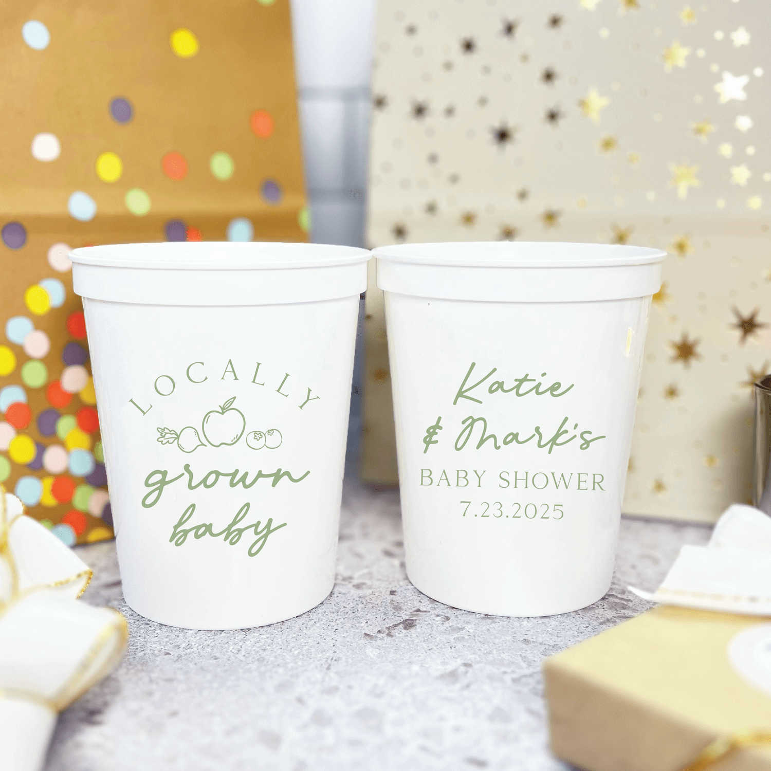 White stadium cups with "Locally Grown Baby" and personalized name with baby shower date in sage green text