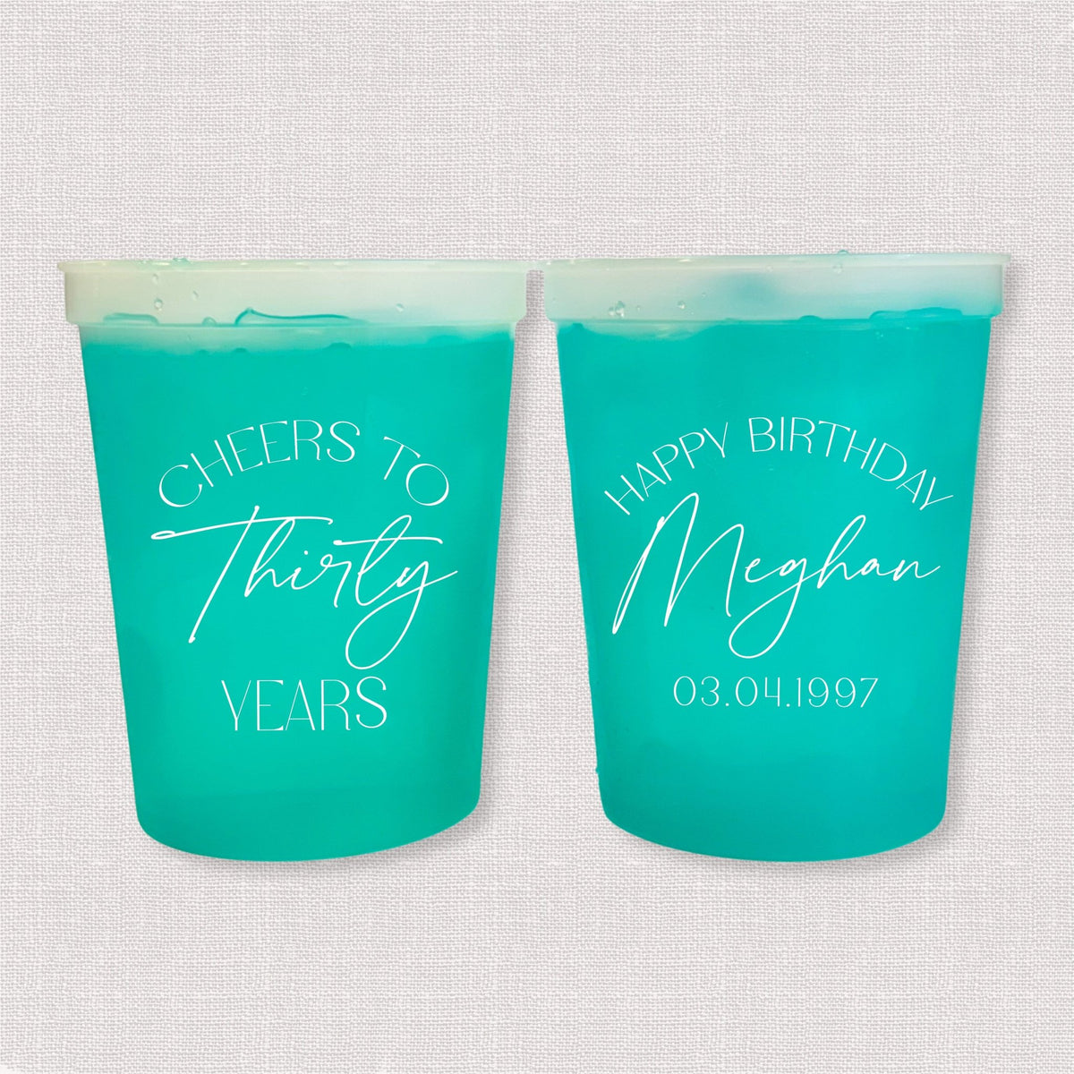 Teal color changing birthday stadium cups with Cheers to Thirty Years arch and Happy Birthday Meghan personalization
