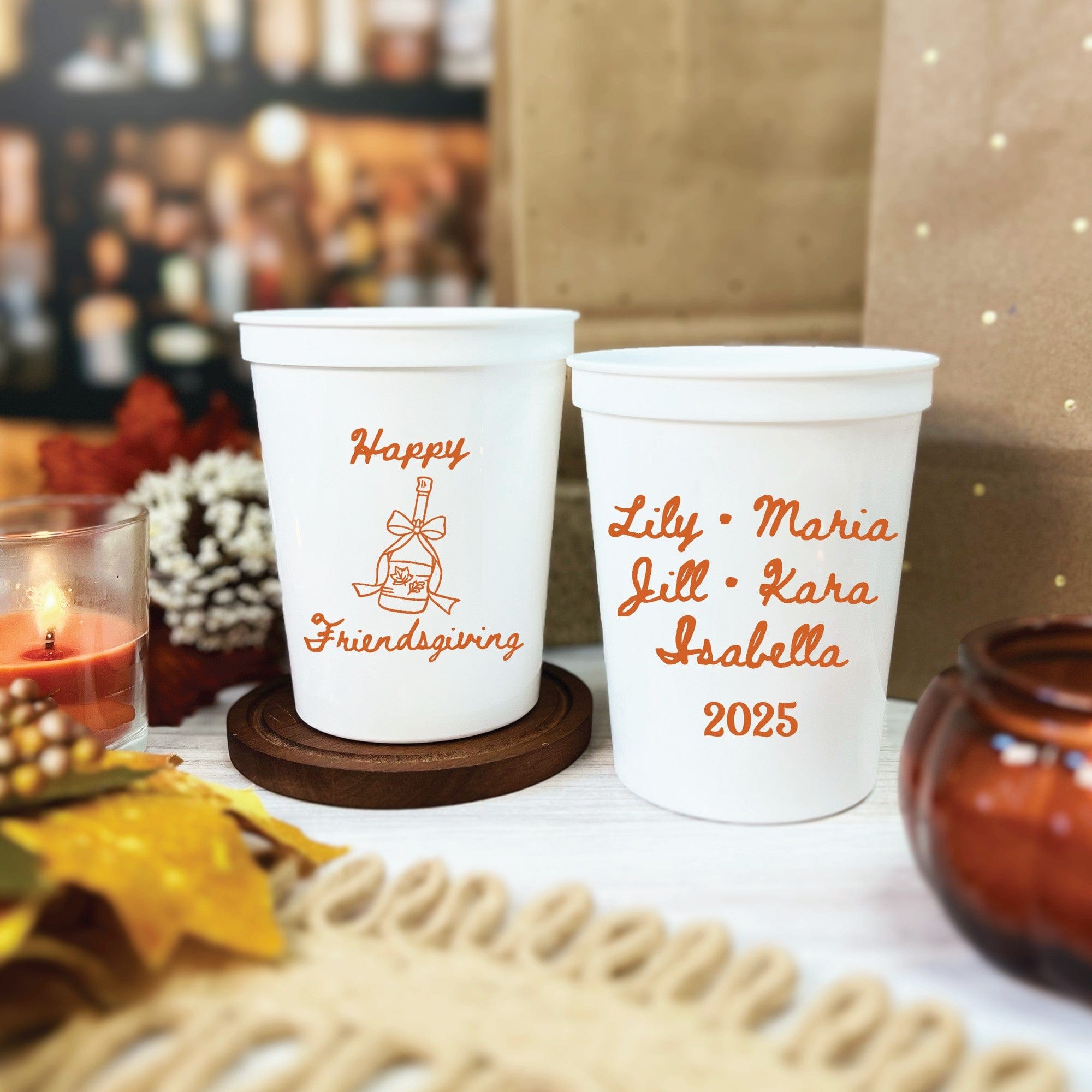 Two white plastic cups featuring personalized fall-themed designs, suitable as custom drinkware or favors for a Friendsgiving or similar autumnal event.