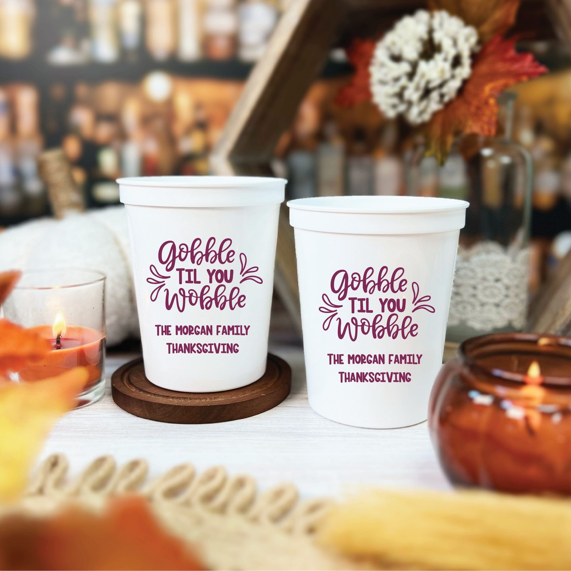 Two white personalized plastic stadium cups feature festive purple text, designed for use during a Thanksgiving celebration.