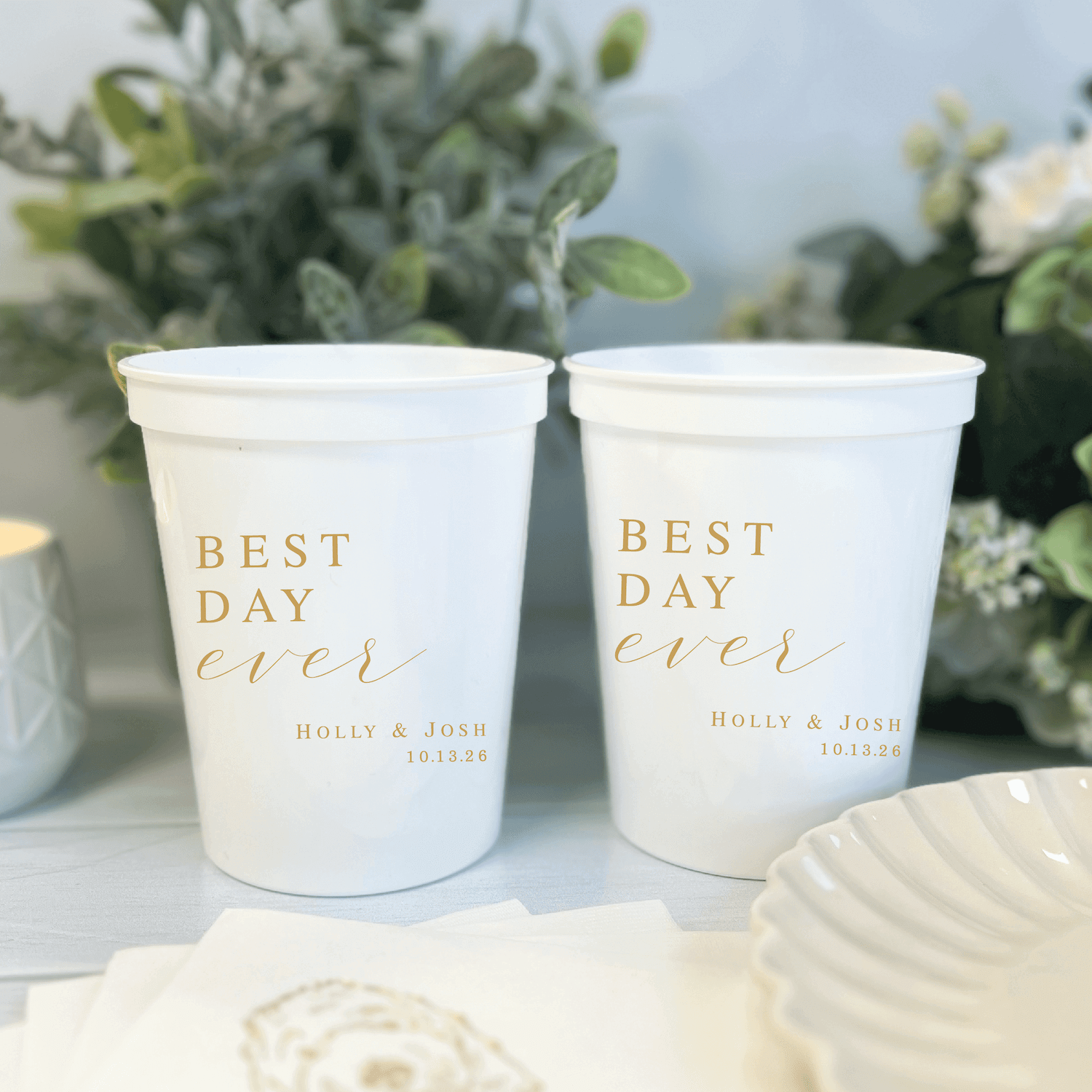 White stadium cups with gold "Best Day Ever" text and personalized names Holly & Josh with date printed below
