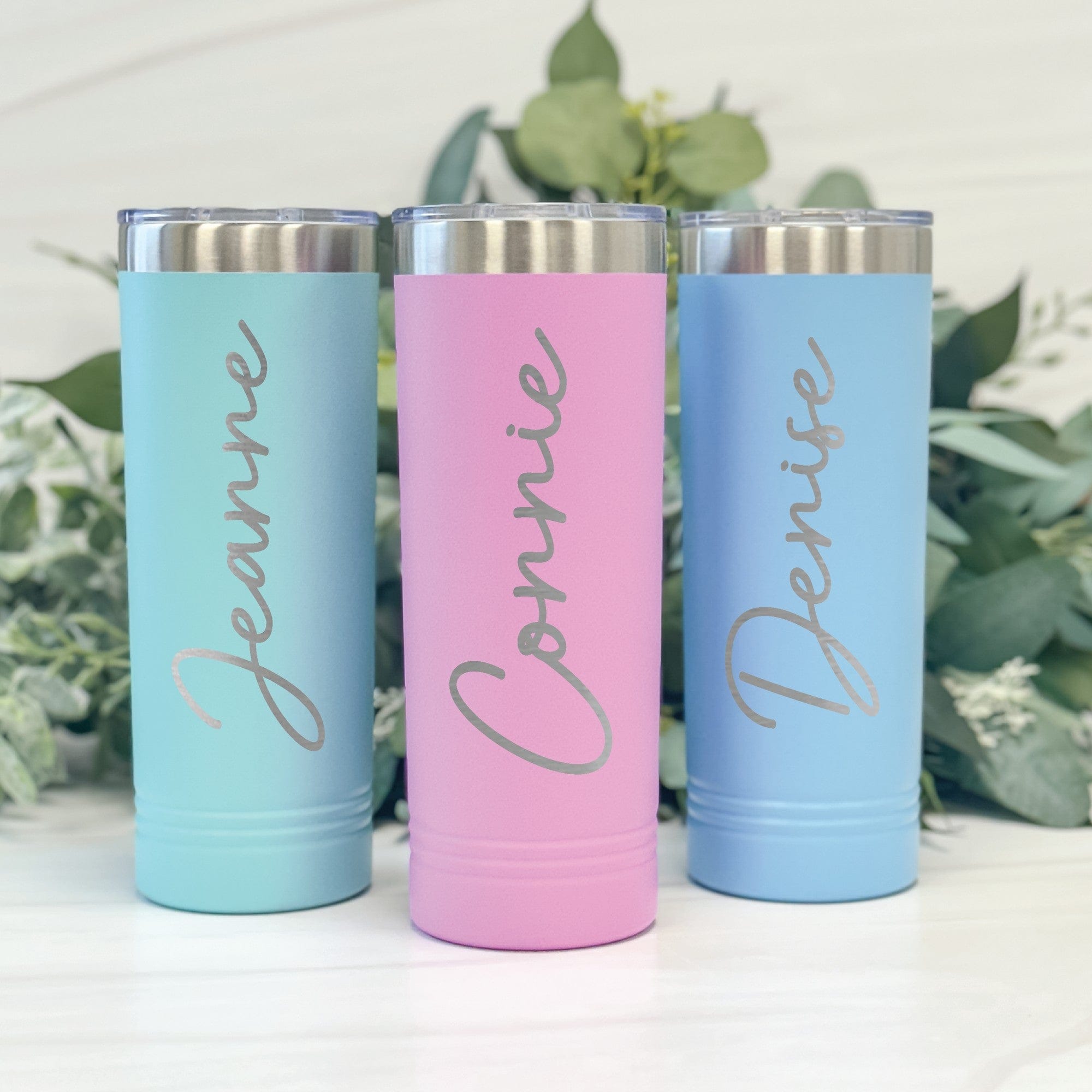 Three matte pastel skinny tumblers in aqua, pink, and light blue, each with a silver lid, displayed for personalized wedding or event drinkware.