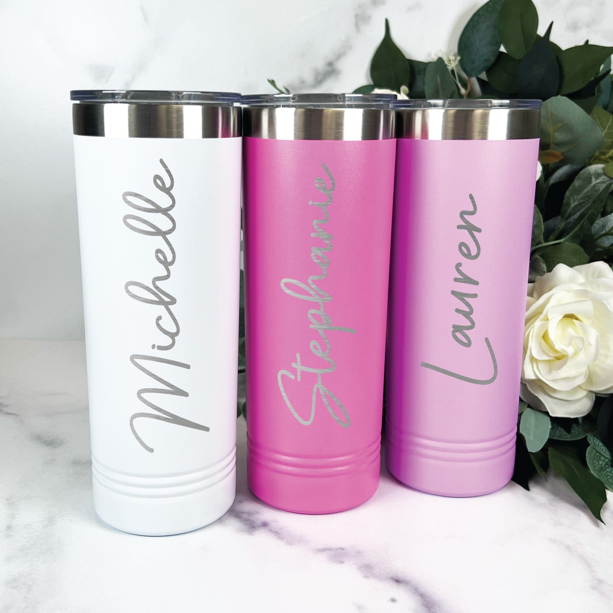 Three personalized insulated stainless steel tumblers in white, fuchsia, and lavender colors, each with a clear lid, designed for a wedding or special event.
