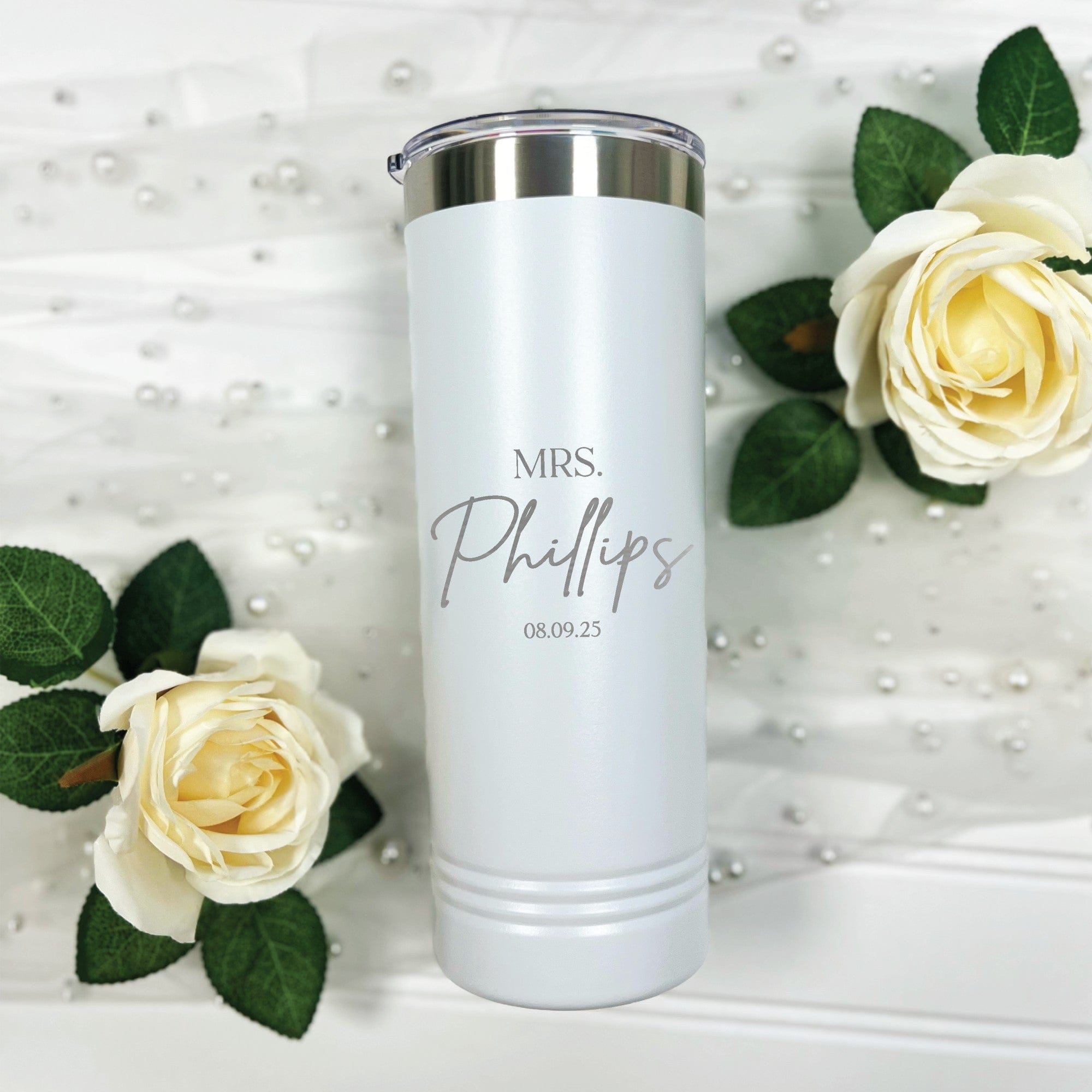 A white insulated stainless steel tumbler with a metallic silver rim and clear lid, featuring light gray personalization, suitable for bridal events and wedding decor.