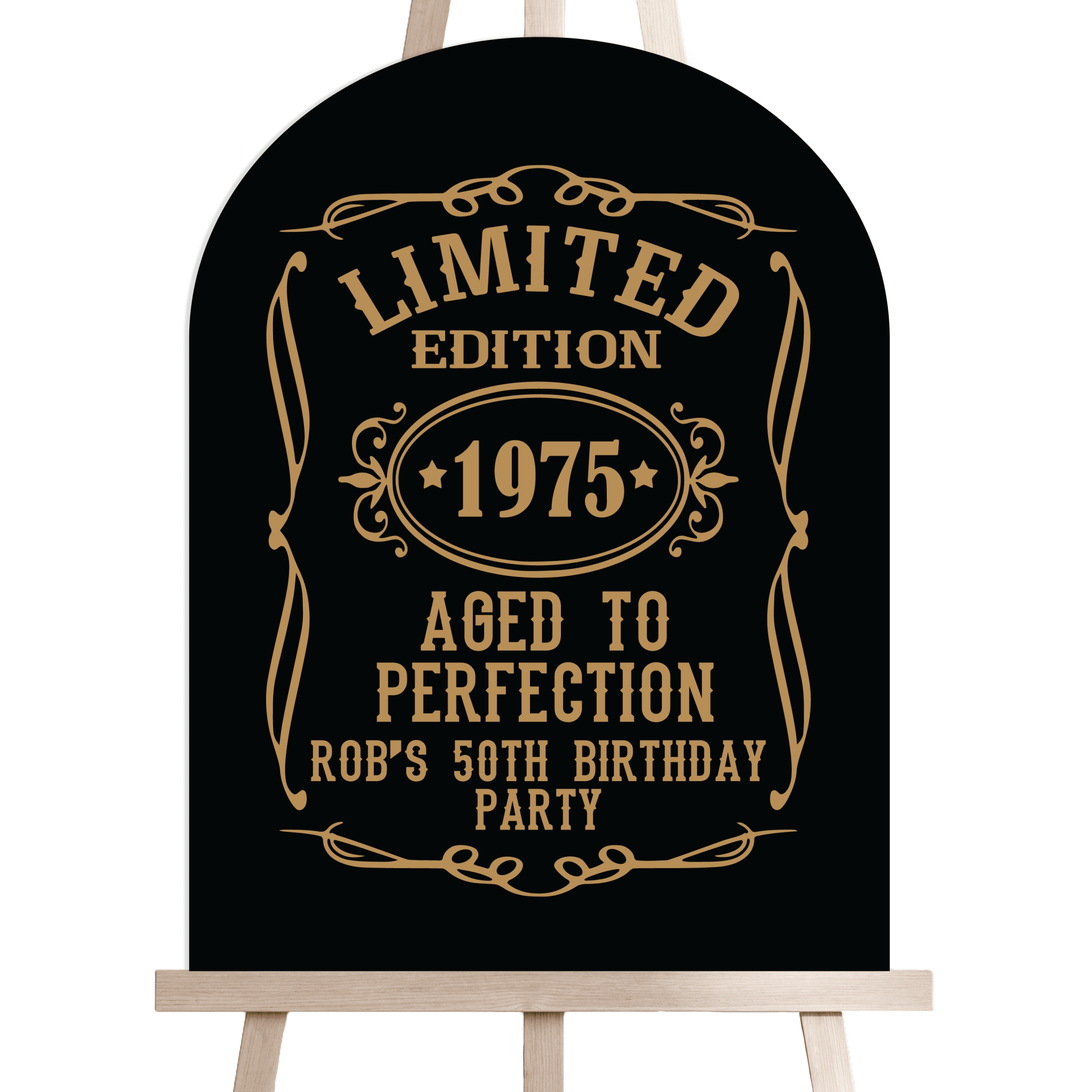 Black wooden arch sign with gold "Limited Edition 1975 Aged to Perfection Rob's 50th Birthday Party" text and decorative border on easel stand