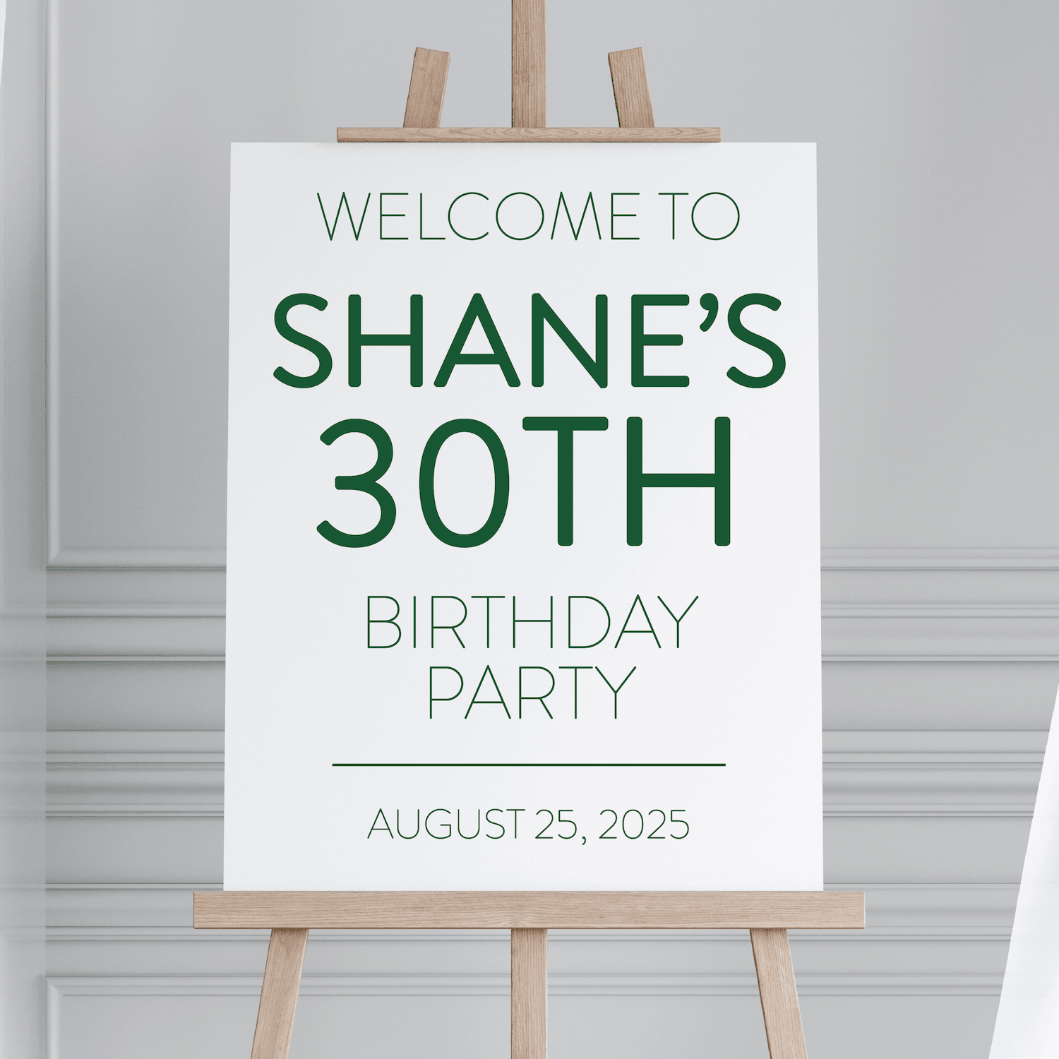 White welcome sign with green text reading "Welcome to Shane's 30th Birthday Party" and date August 25, 2025, displayed on wooden easel.