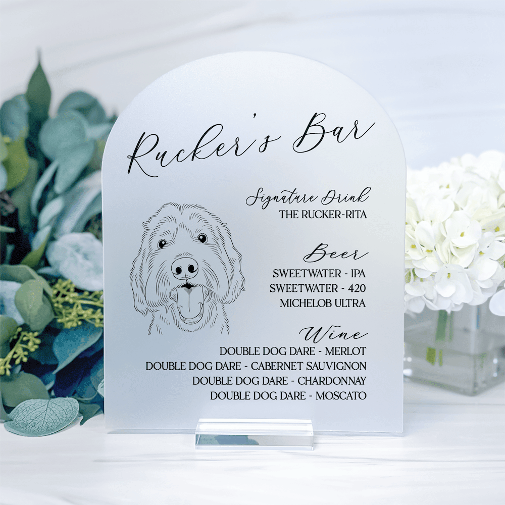 Arched acrylic drink menu sign featuring illustrated dog and "Rucker's Bar" text with beer and wine selections listed below.