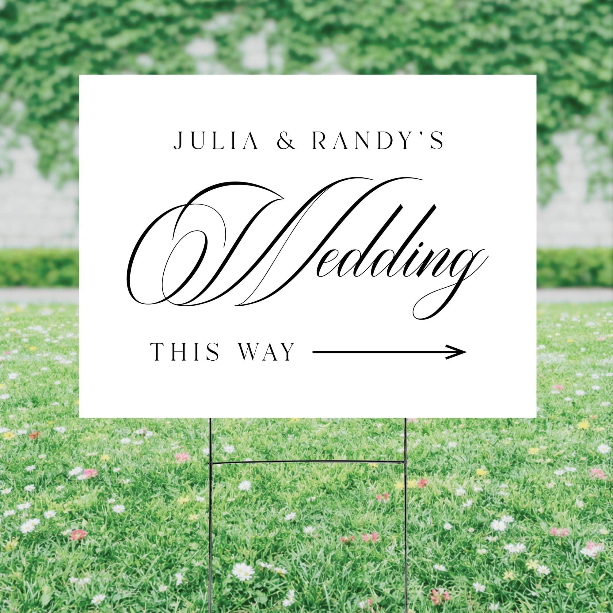 A white corrugated plastic yard sign with black elegant text and a directional arrow, mounted on a metal H-stake in green grass, designed to guide guests to a wedding.