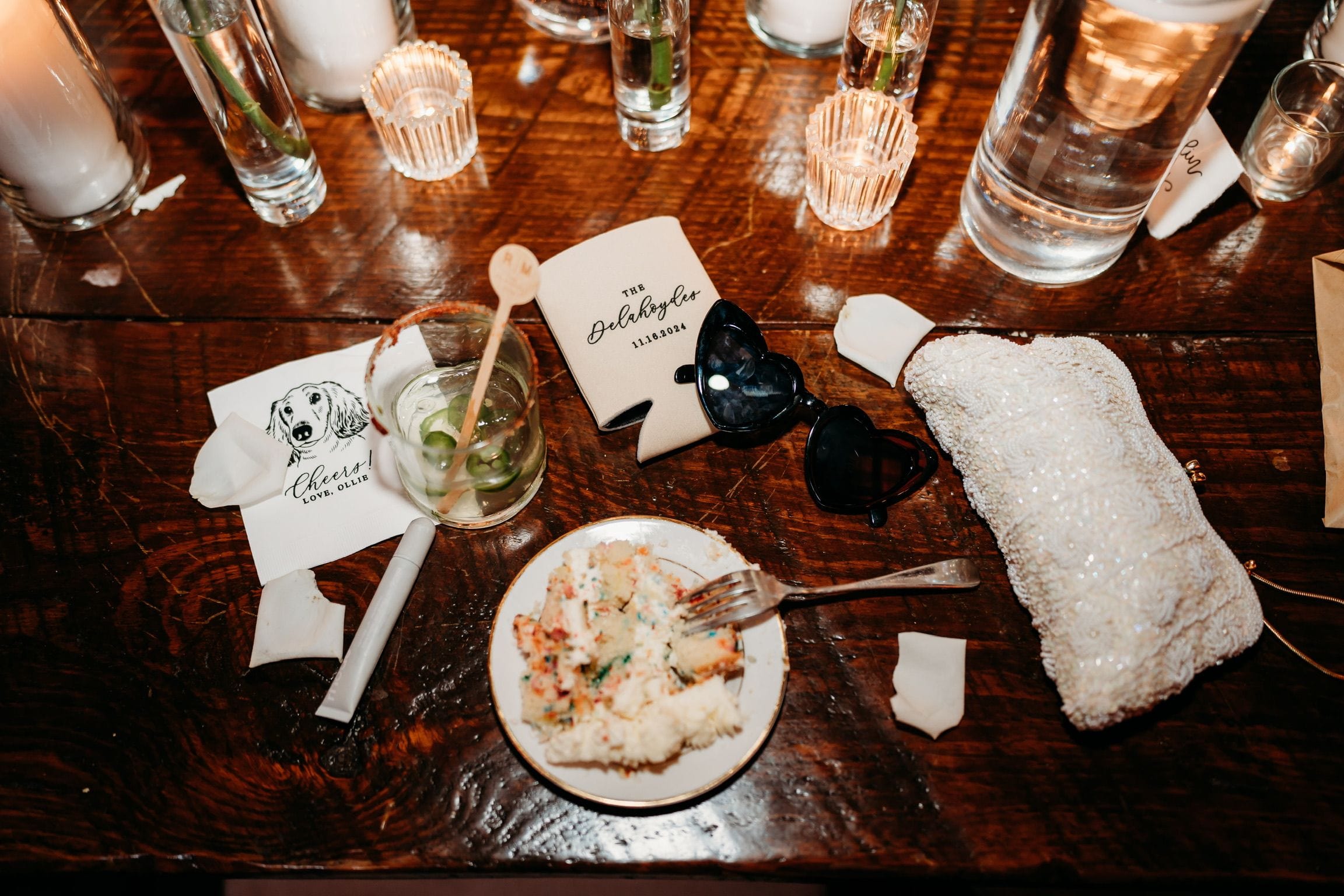 A custom koozie and personalized wedding napkin arranged together as a thoughtful wedding favor set.
