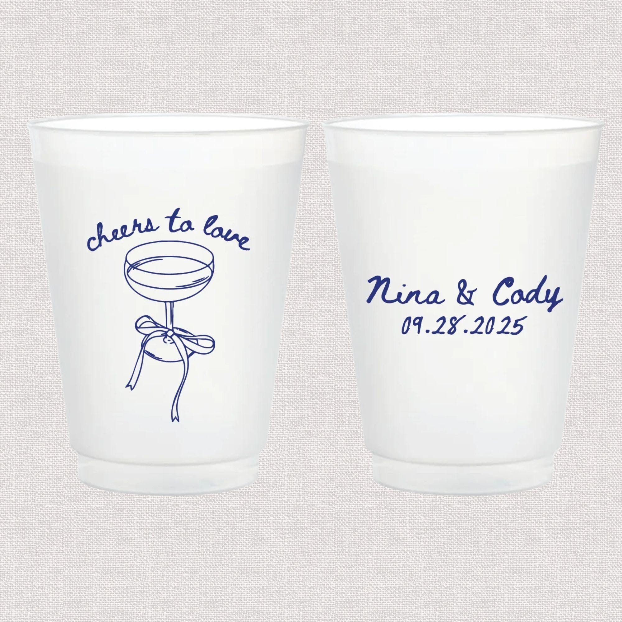 Pair of frosted plastic cups with blue script text reading "cheers to love" and a cocktail illustration on one side, personalized names and wedding date on the other